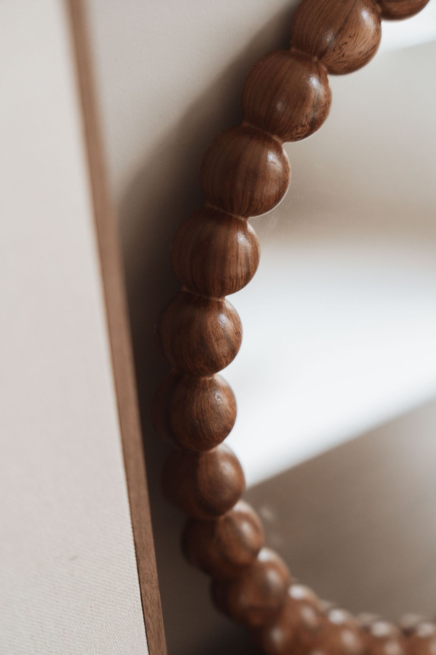 Close-up detail of carved wooden beads creating a decorative pattern on furniture.