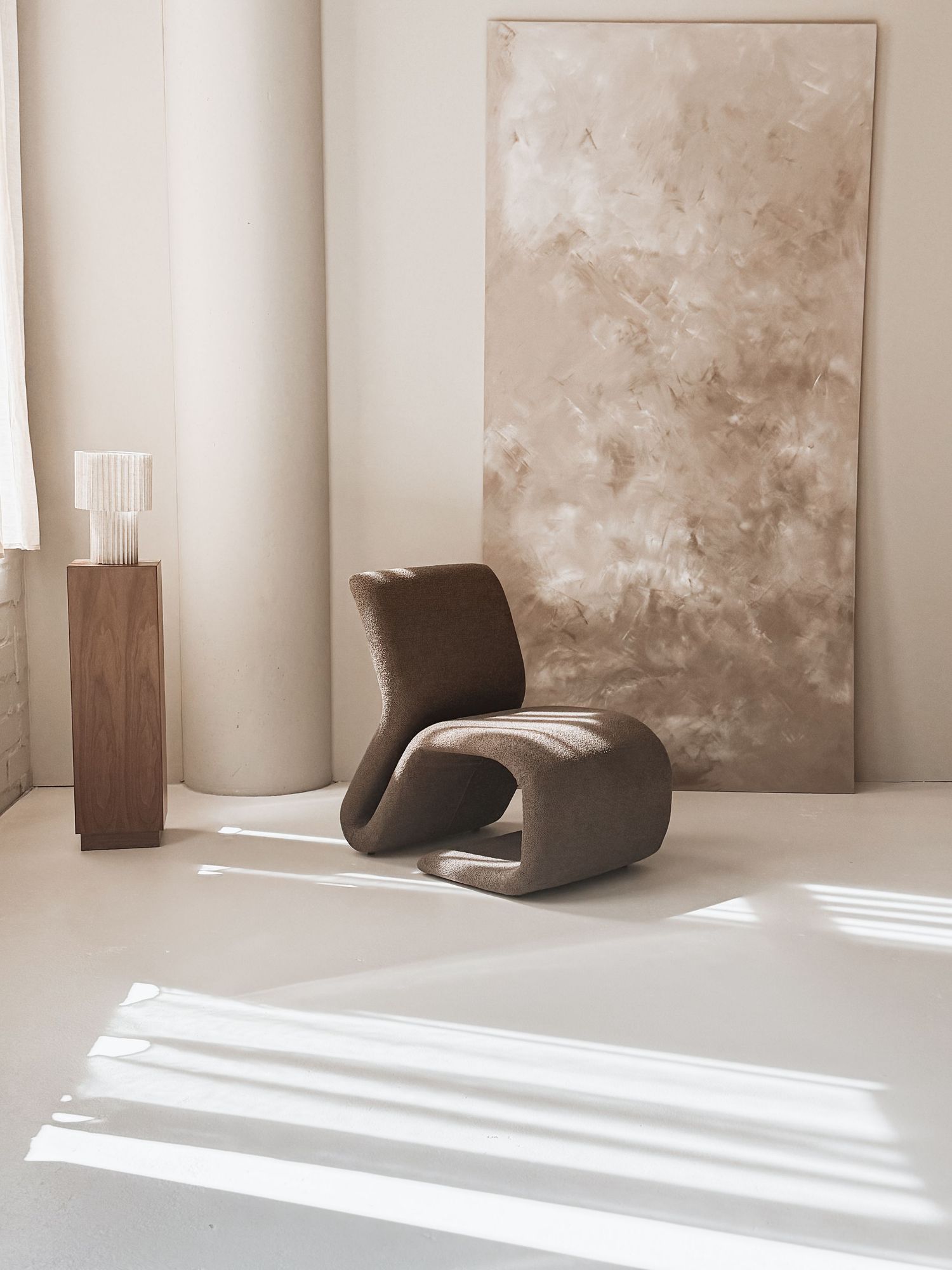 Minimalist interior space with curved chairs and abstract artwork in neutral tones.