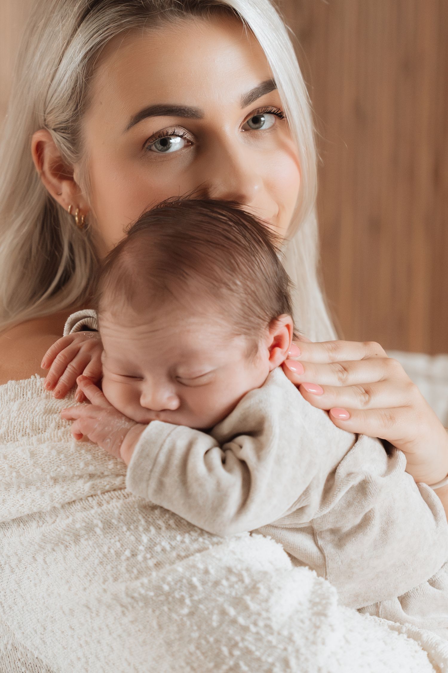 A series of intimate portrait photos showing tender moments between parent and child against a warm wooden background.