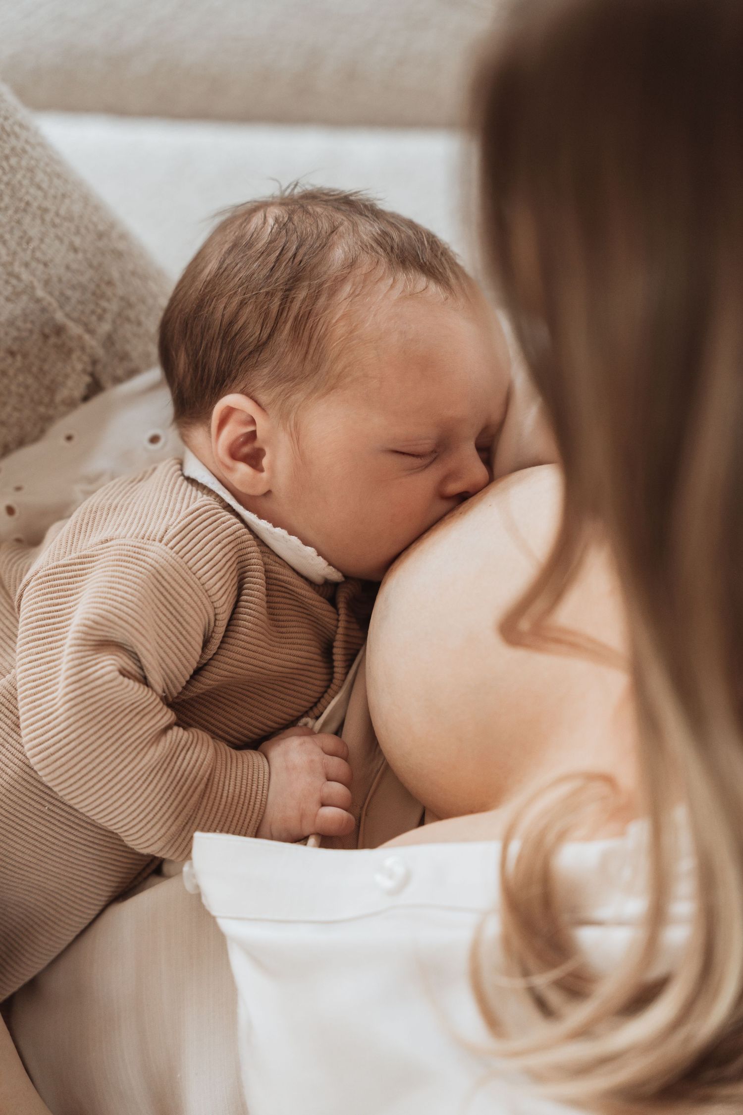 Intimate nursing moment captured in soft, warm tones.