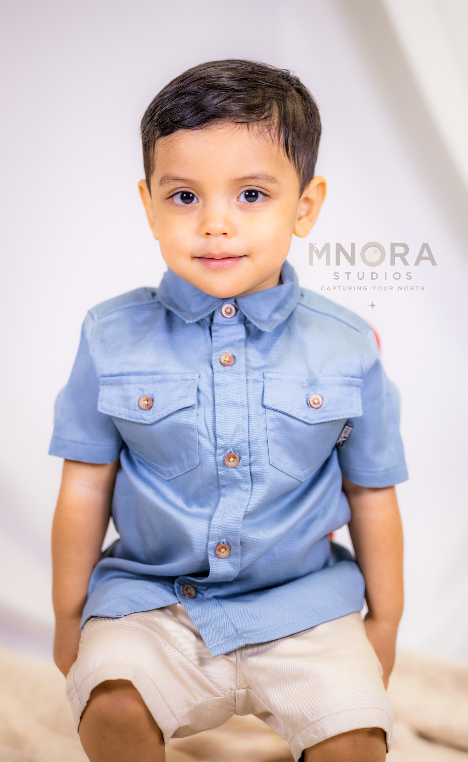 Toddler boy in blue outfit sitting for studio portrait session