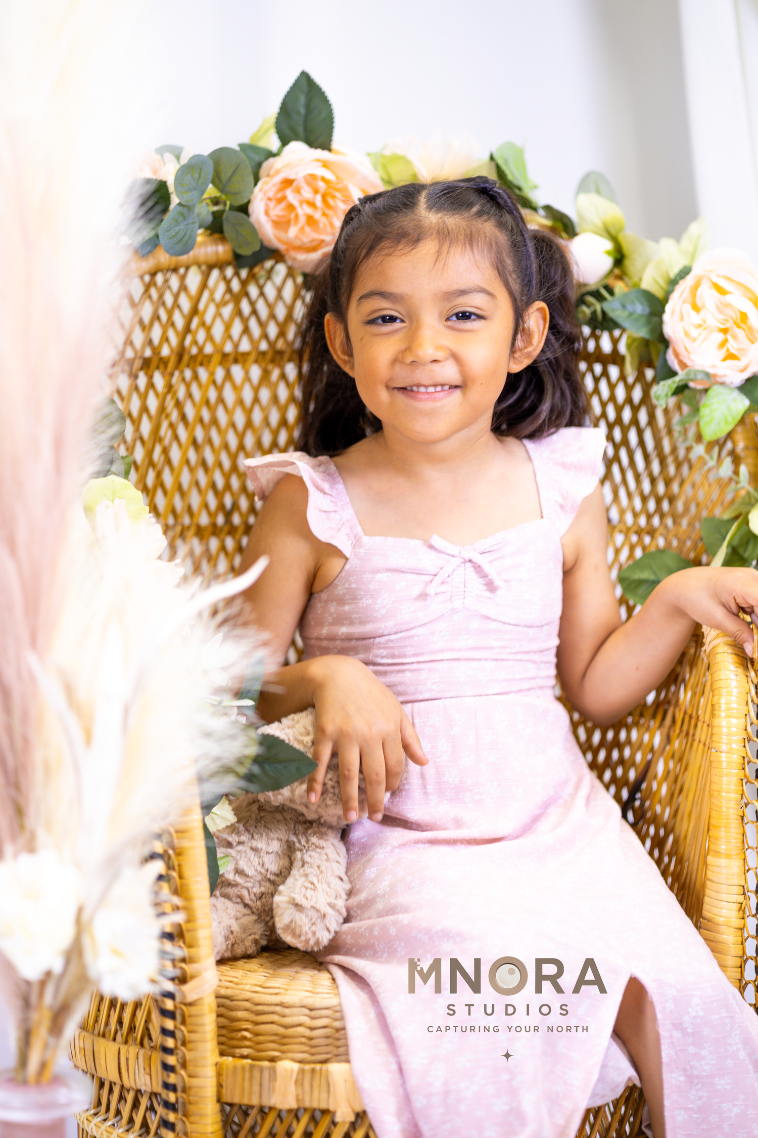 Young girl smiling in pink dress during MNORA Studios portrait session