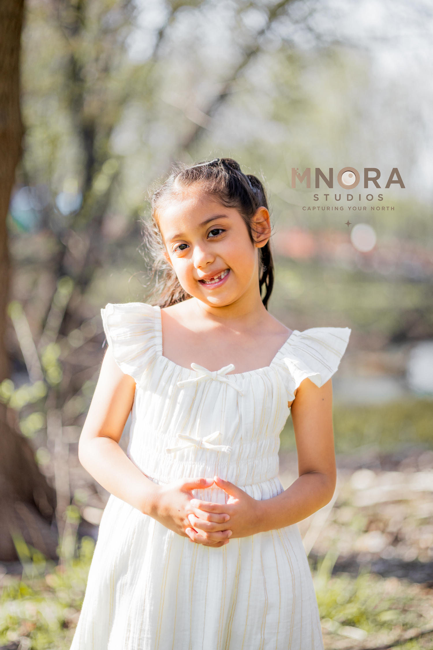 Girl in white dress holding flowers during outdoor spring portrait session in Minneapolis