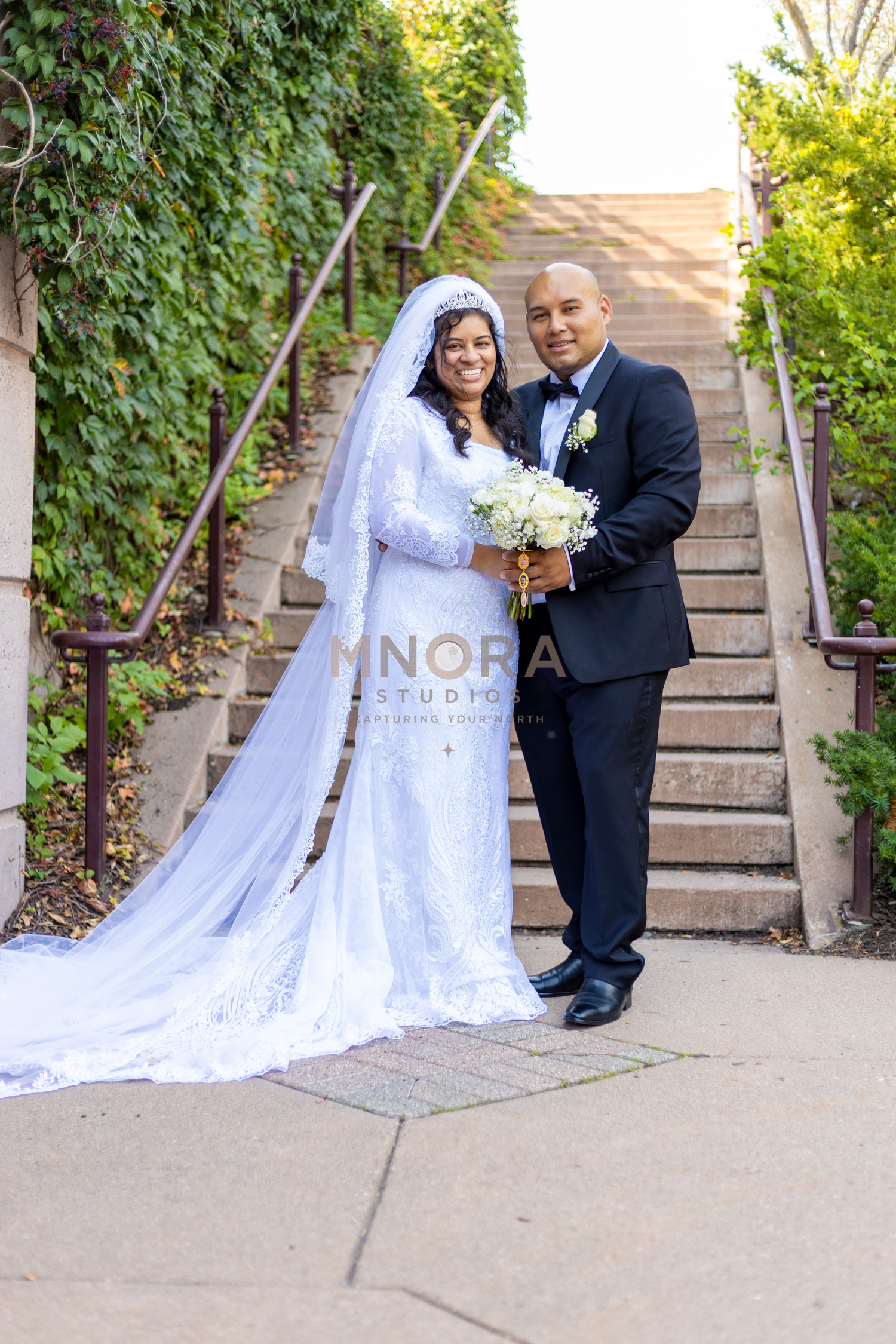 Bride and groom smiling on brick steps during Minneapolis wedding portrait