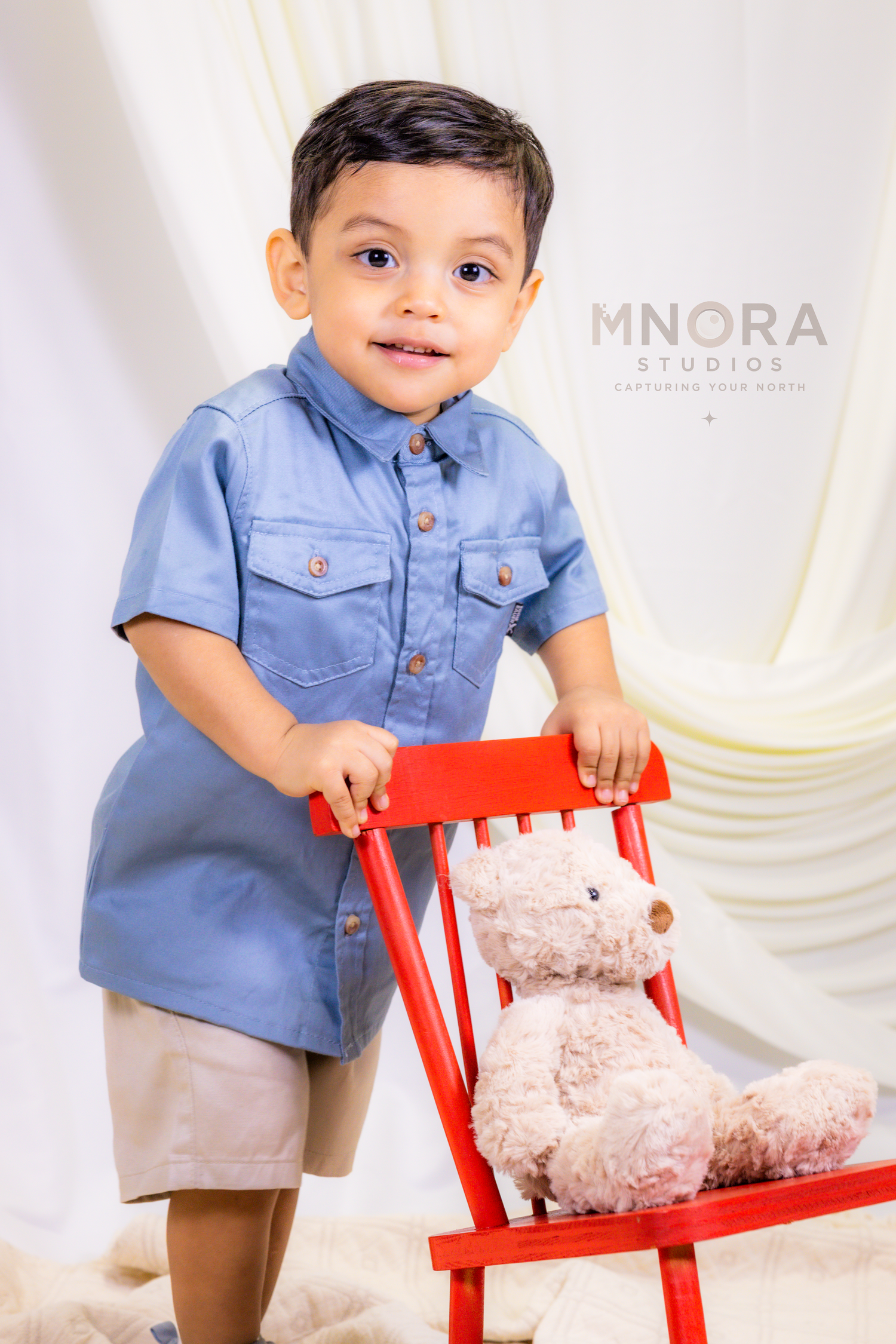 Close-up studio portrait of toddler boy in blue outfit at MNORA Studios