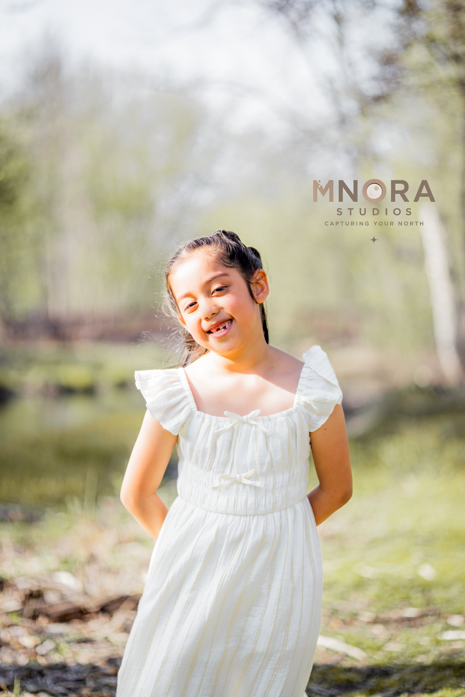Candid outdoor portrait of girl in white dress and cardigan at Minneapolis park