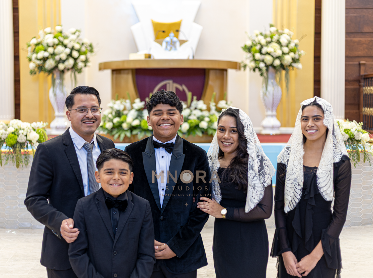 Family dressed in formal attire posing inside church after ceremony in Minneapolis