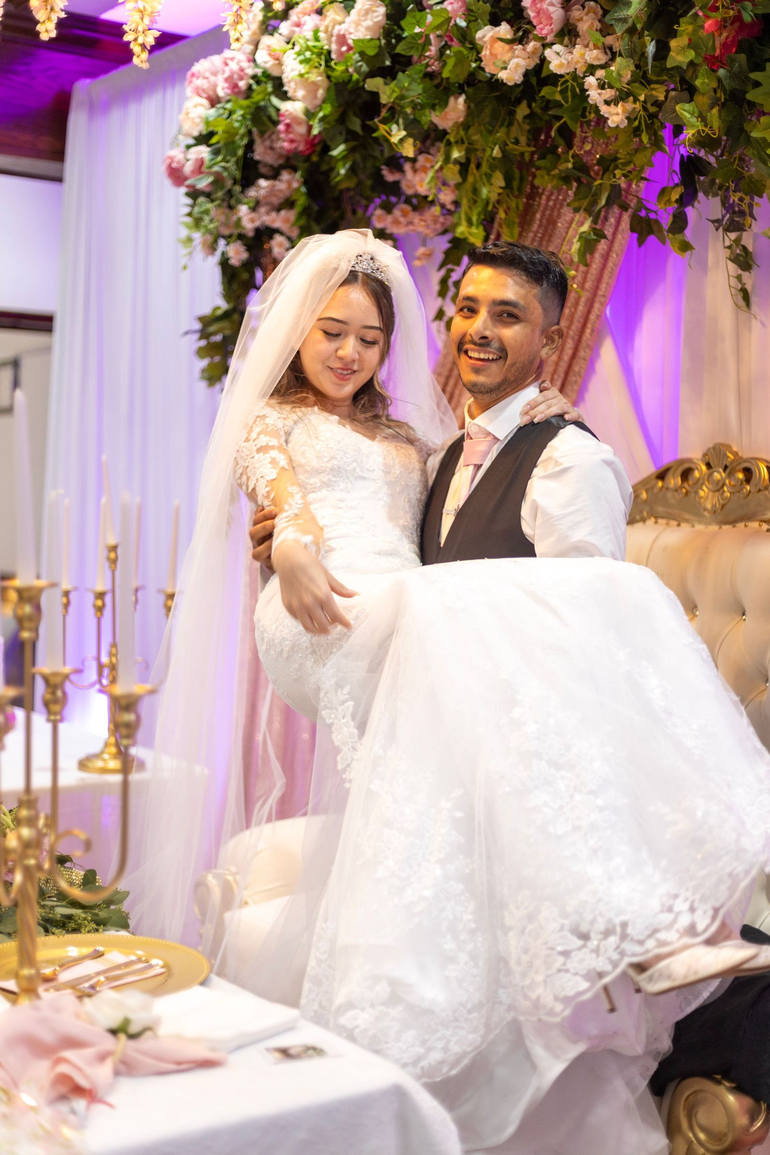 Bride seated on stage in traditional outfit during colorful wedding celebration