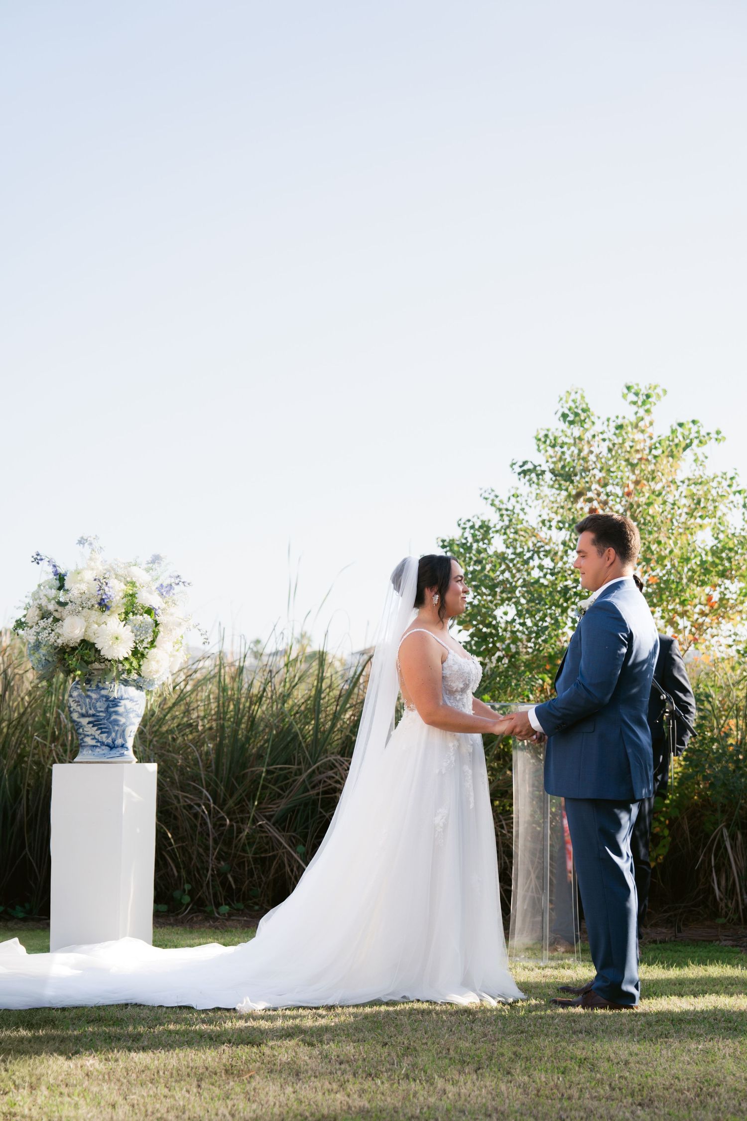 A bride and groom share a tender first look moment in a garden setting during their outdoor wedding ceremony in Virginia Beach