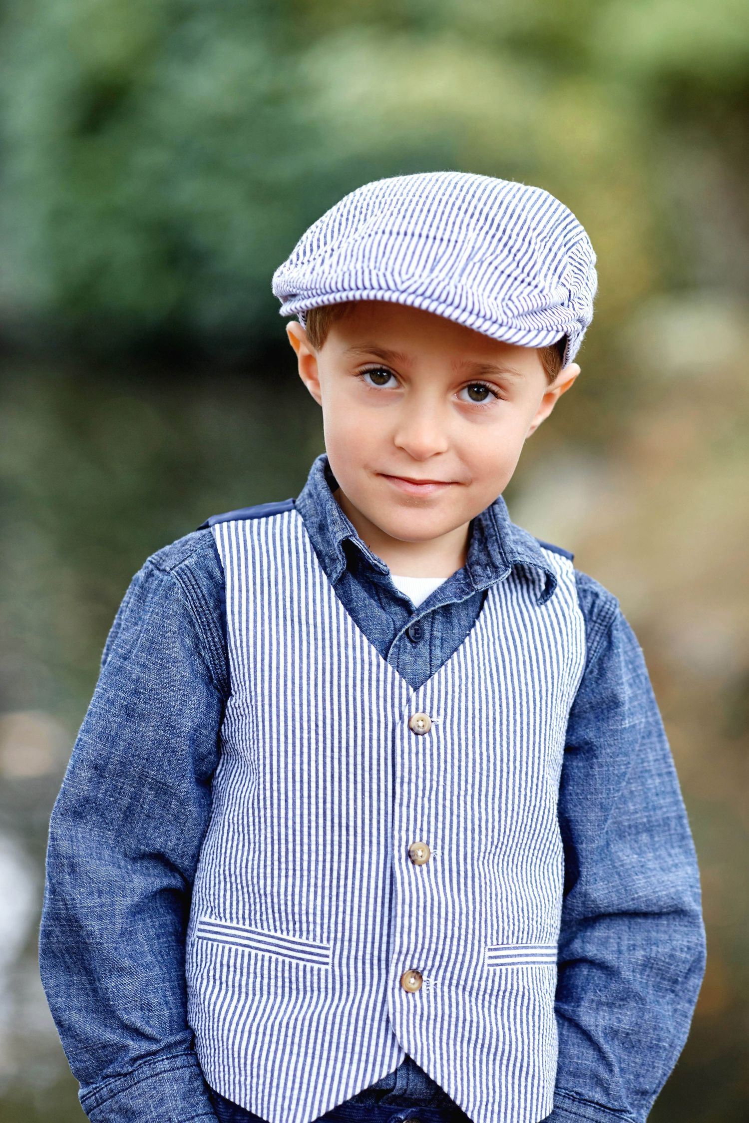 Portrait of a young child wearing a striped cap and denim outfit in an outdoor Seattle session.