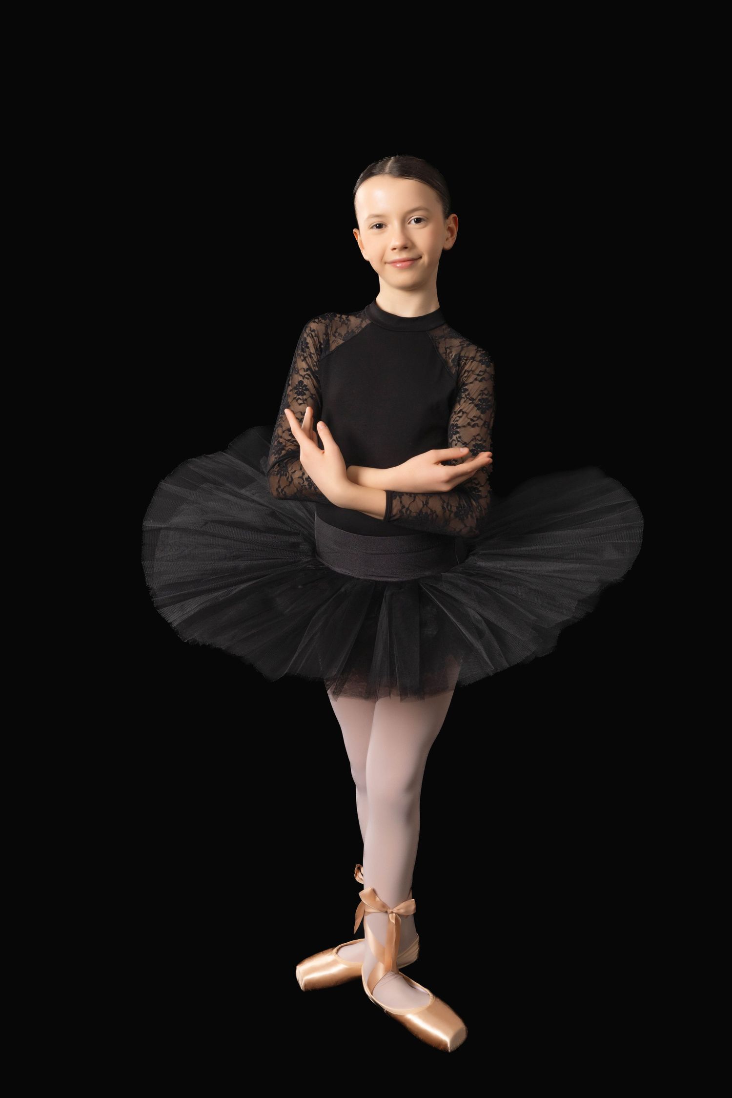 Photo of a young ballet dancer in black tutu and pink tights poses gracefully against dark background in multiple positions.