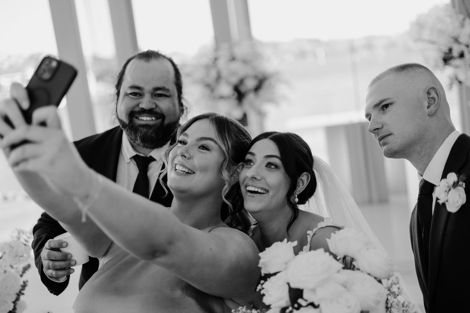 A collection of black and white wedding photos showing candid moments of celebration and joy at a reception.