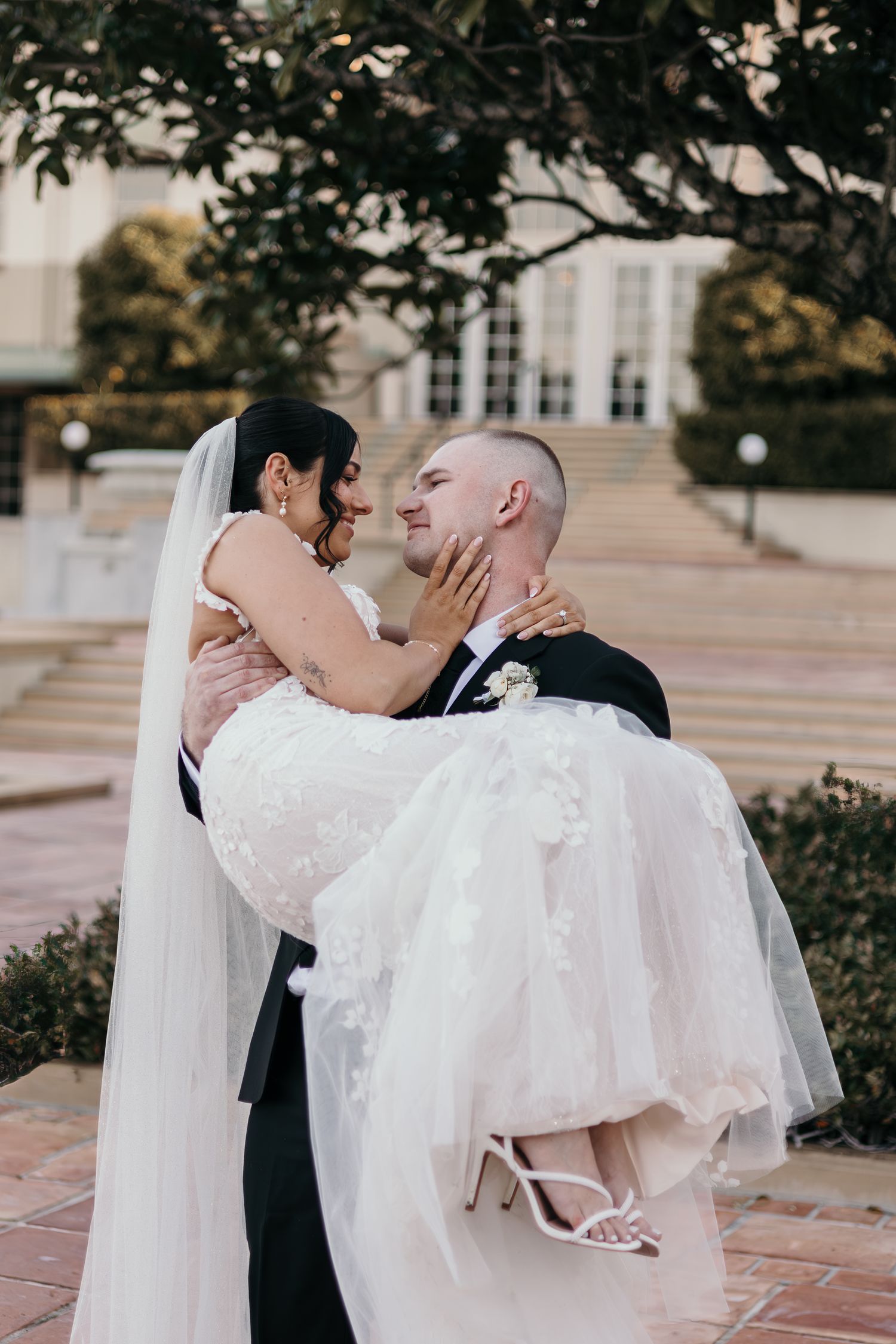 A romantic wedding couple shares intimate kisses in a series of outdoor portraits on a terrace.