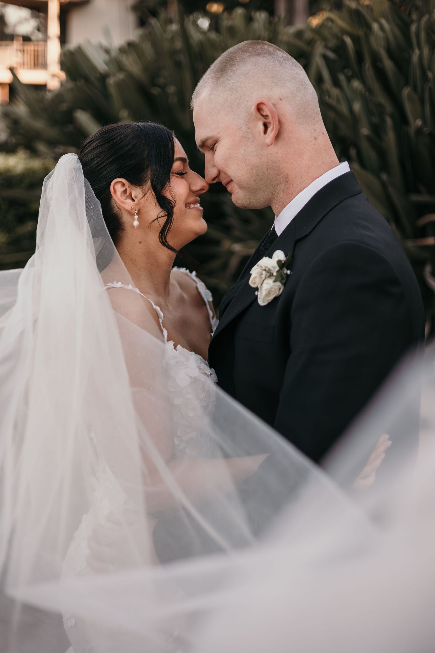 A romantic wedding moment captured in a series of close-up shots with flowing white veil in the foreground.