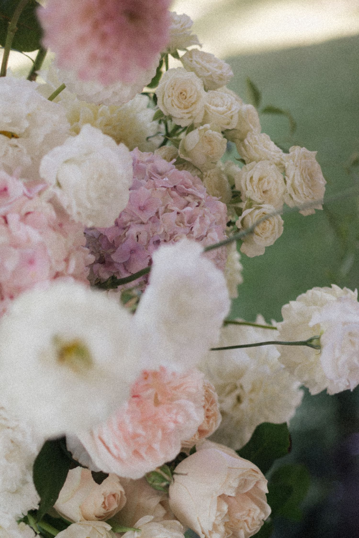 Lush floral arrangement with white roses, pink hydrangeas, and blush garden roses for an elegant wedding centerpiece.