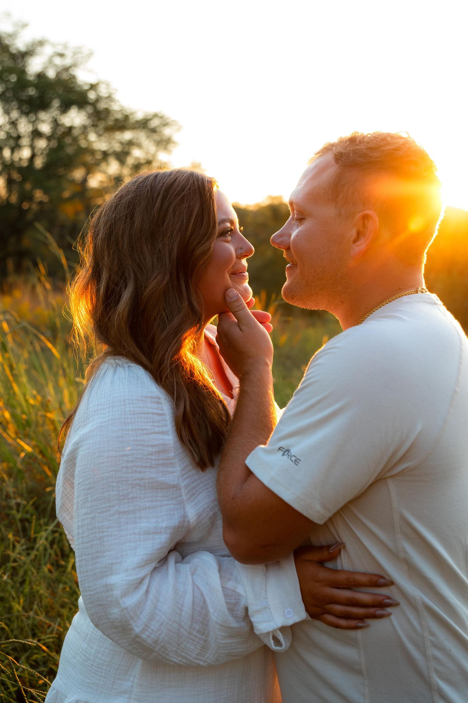 Intimate couple portraits captured during sunset in tall grass with warm backlighting at Queeny Park near St. Louis.