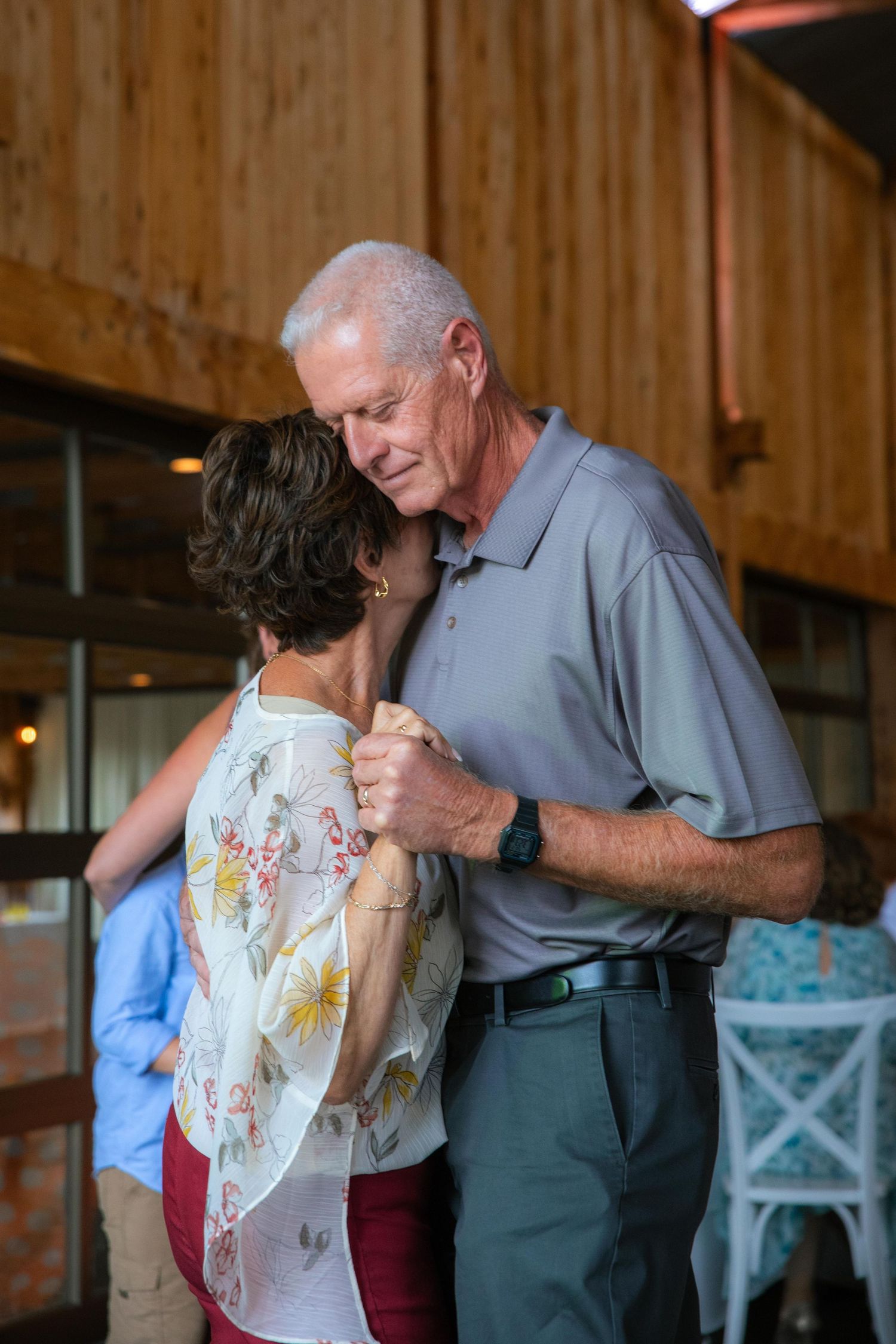 Couples slow dancing together in a rustic wooden barn venue in St. Charles, Missouri.