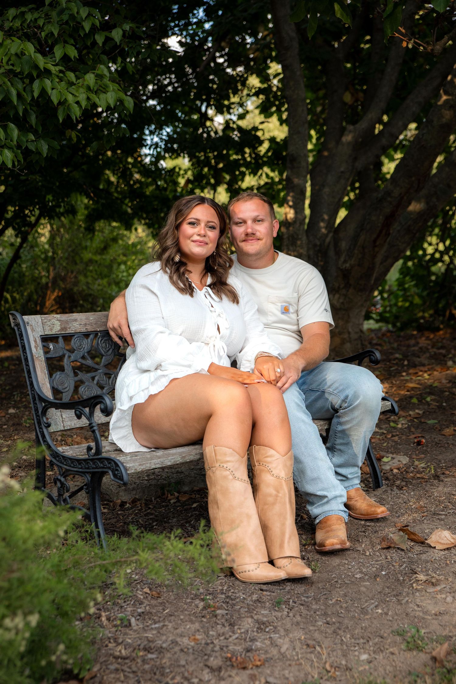 Couple sitting together on a park bench surrounded by green trees and natural scenery at Queeny Park near St. Louis.