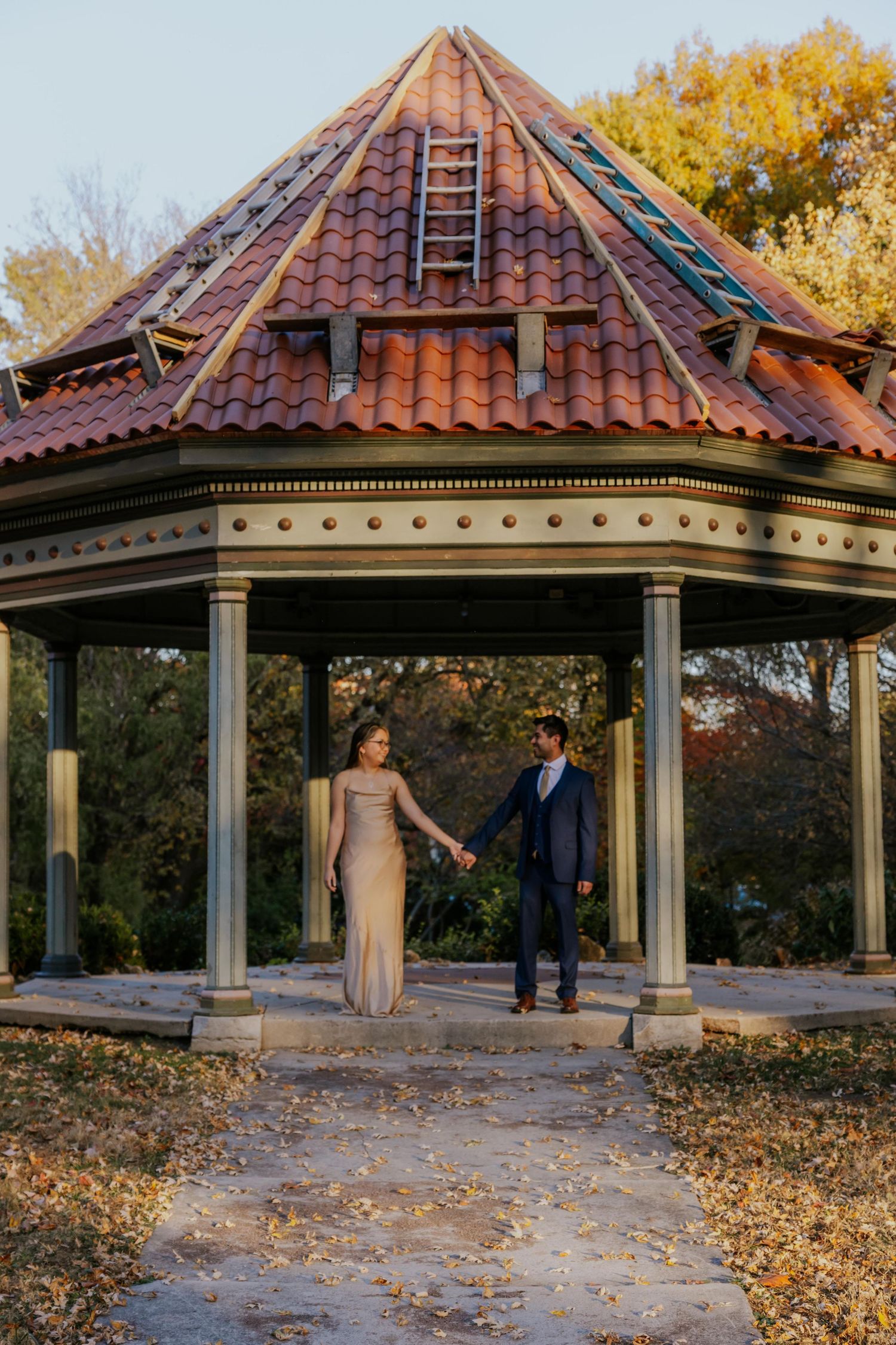 A gazebo with red tile roof surrounded by fall foliage in a park setting at Lafayette Park in St. Louis.