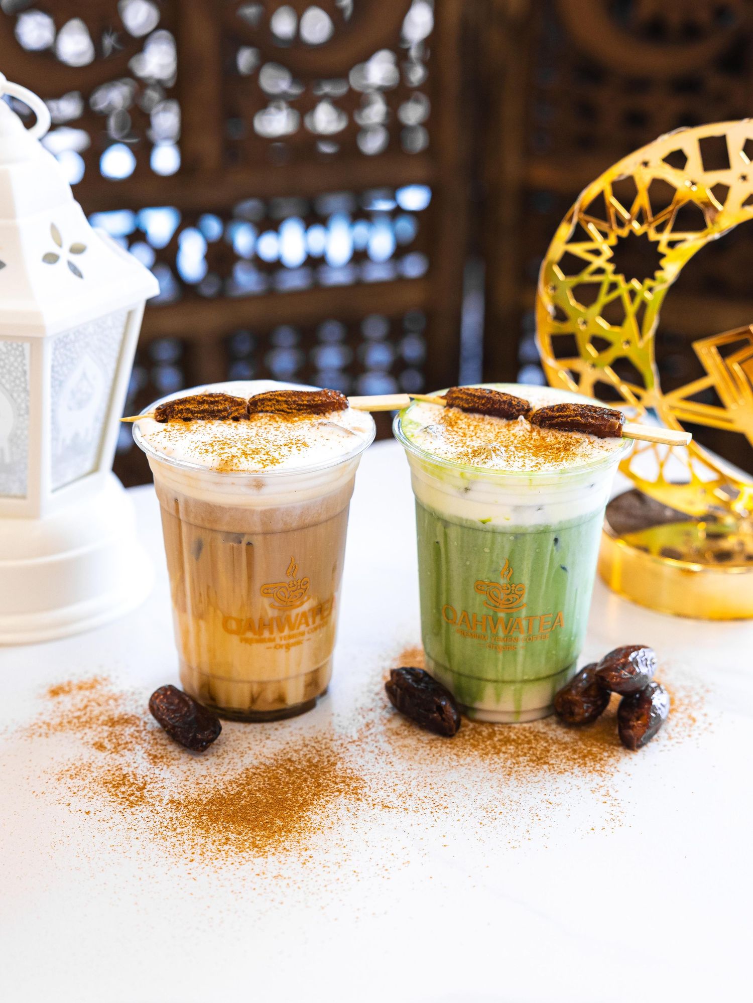 A row of colorful coffee drinks with cocoa powder garnish and coffee beans lined up on a white counter.
