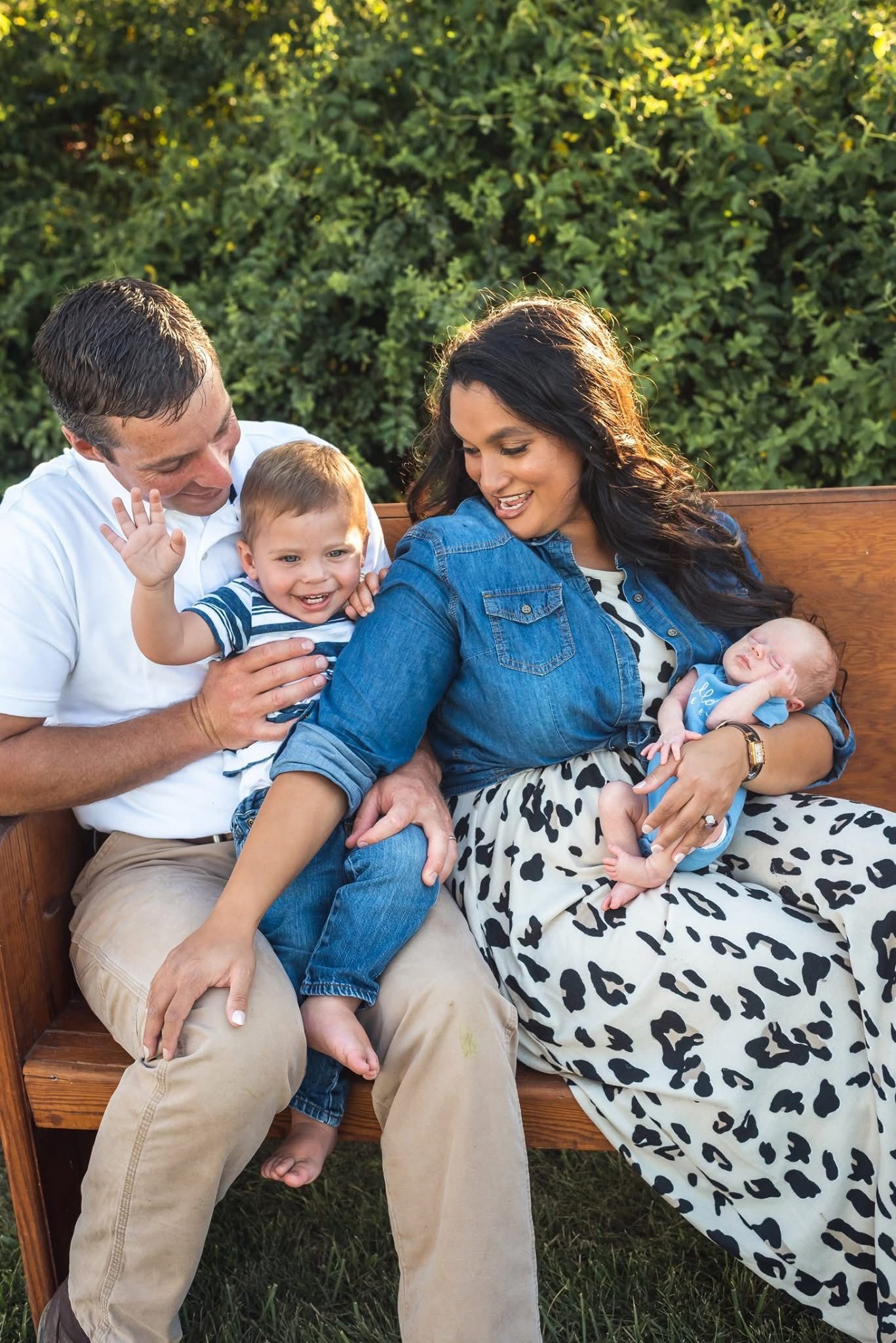 A family sits together on a wooden bench outdoors sharing a tender moment in Springfield, Mo.
