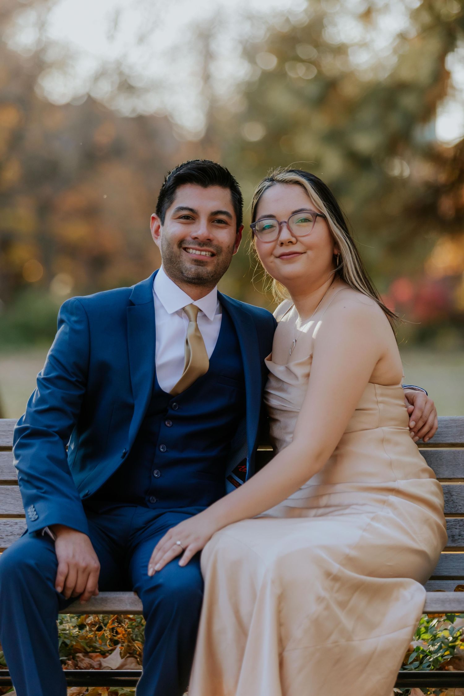 Couple sitting on bench sharing intimate moment during fall photoshoot at Lafayette Park in St. Louis.