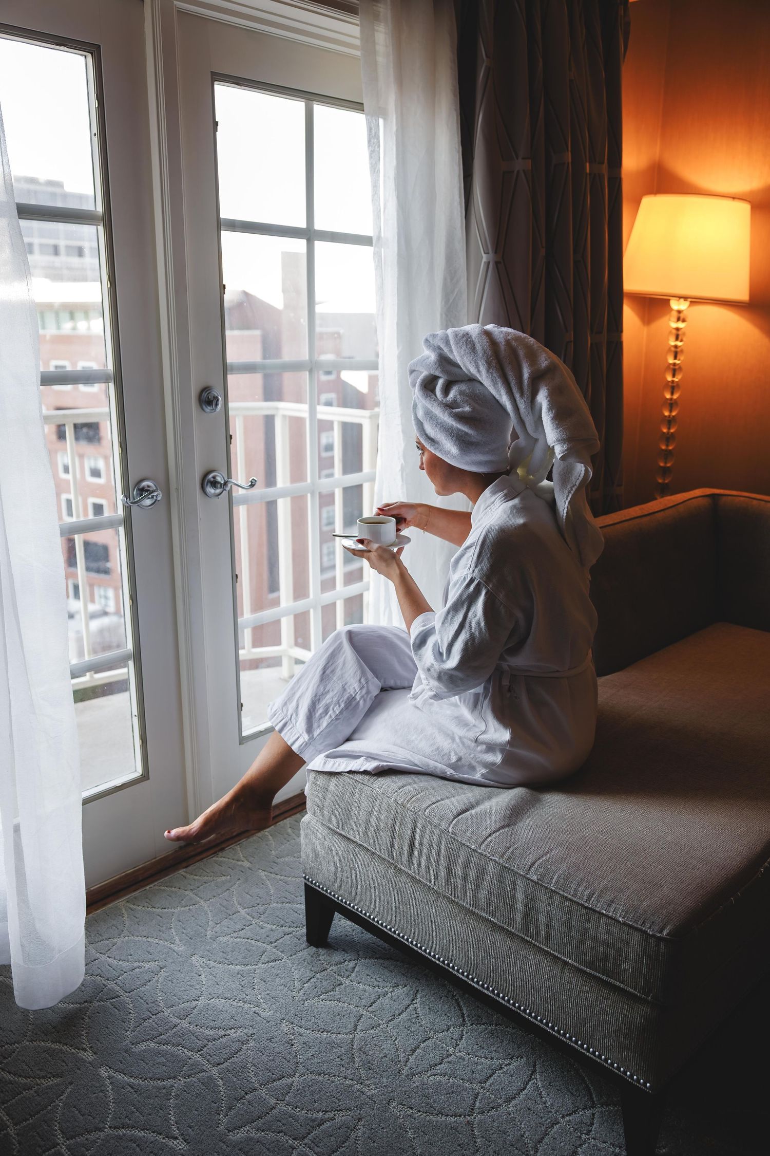 A series of photos showing a person in white lounging on a grey couch near a window with warm lighting.