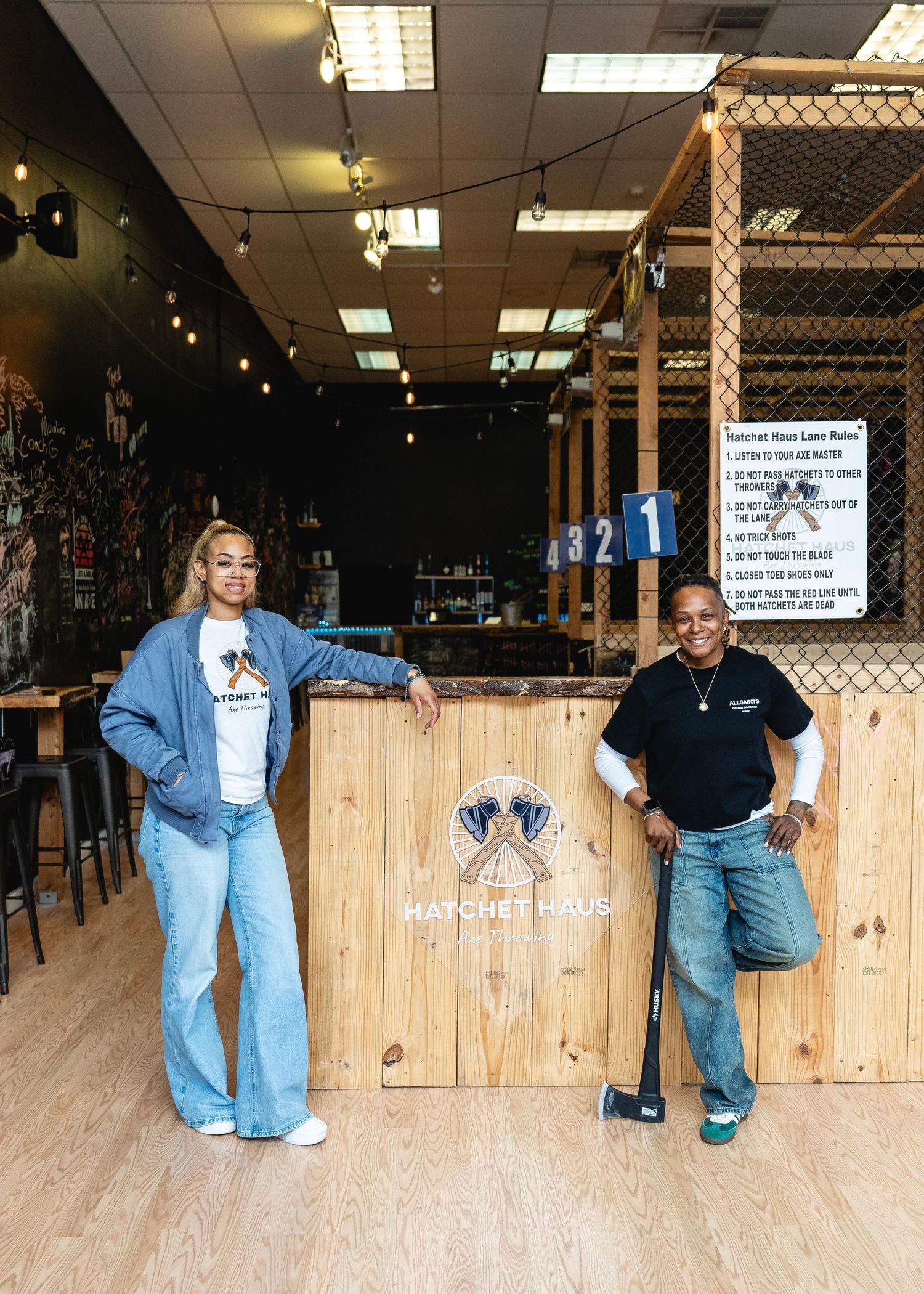 Restaurant staff posing behind wooden counter panels.