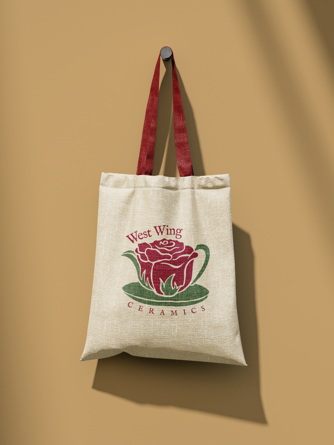 Canvas tote bags with West Wing Ceramics rose logo against beige background.