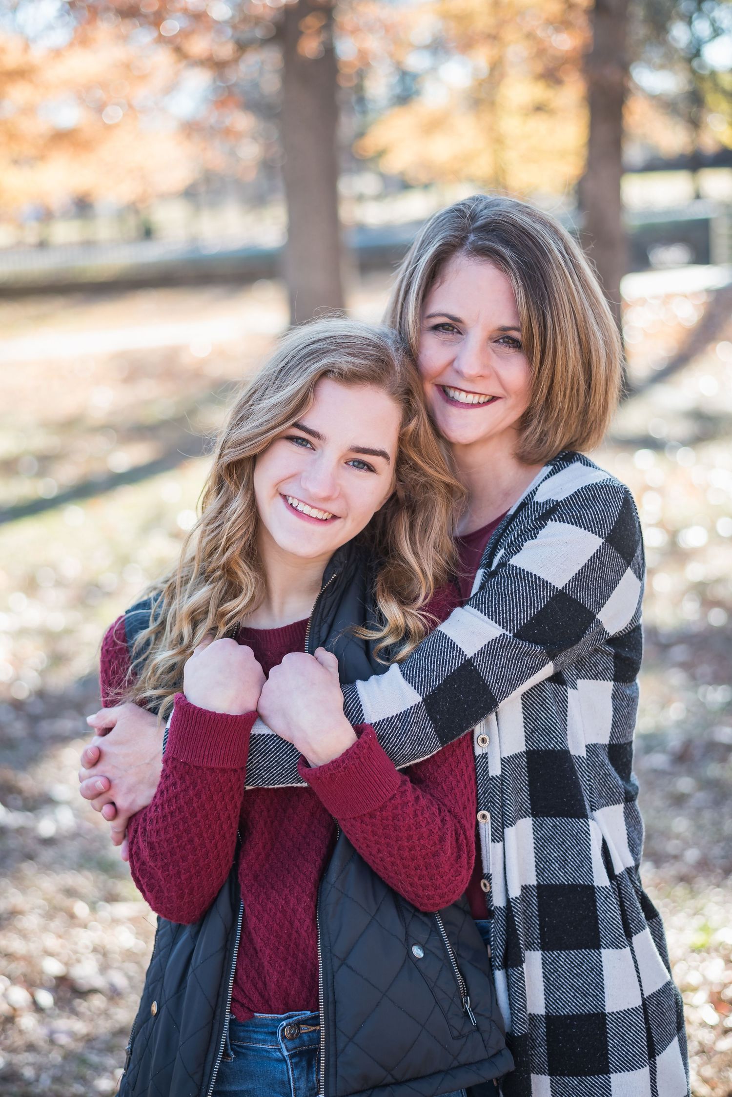Casual outdoor portrait in fall setting with autumn trees in background.