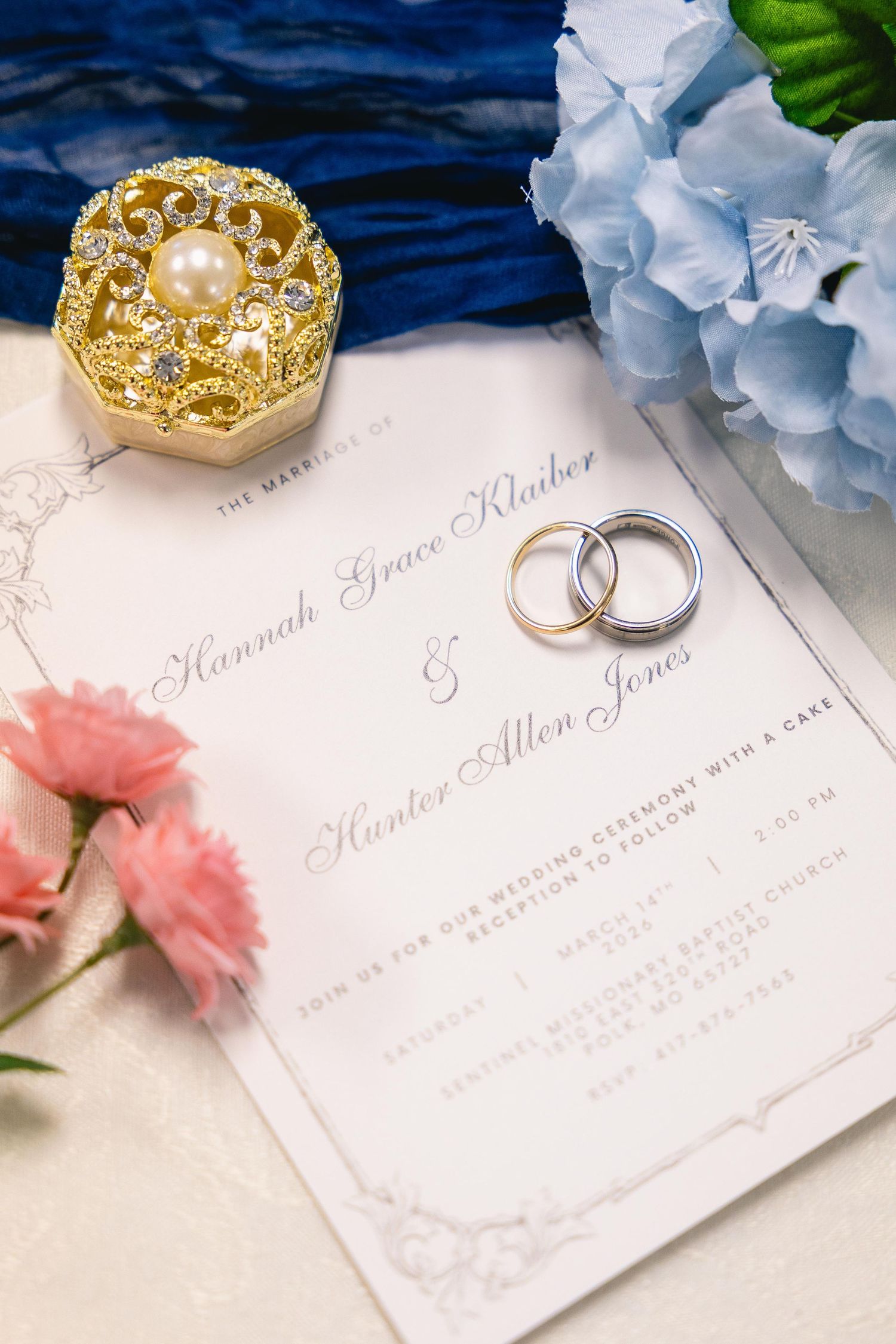 Wedding invitation for Hannah Grace Klauber and Hunter Allen Jones with gold rings and floral decor.