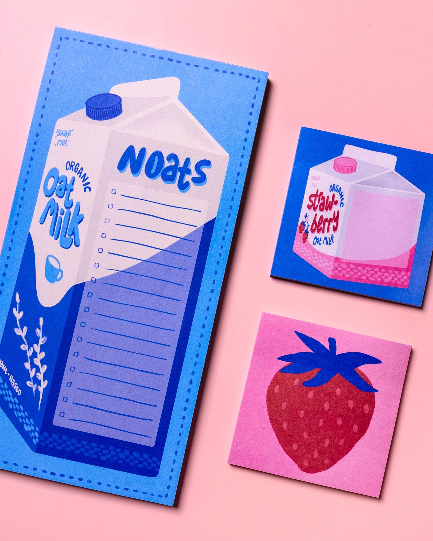 Colorful paper craft designs featuring a milk carton notepad in blue, alongside pink and blue cards with strawberry and milk motifs.