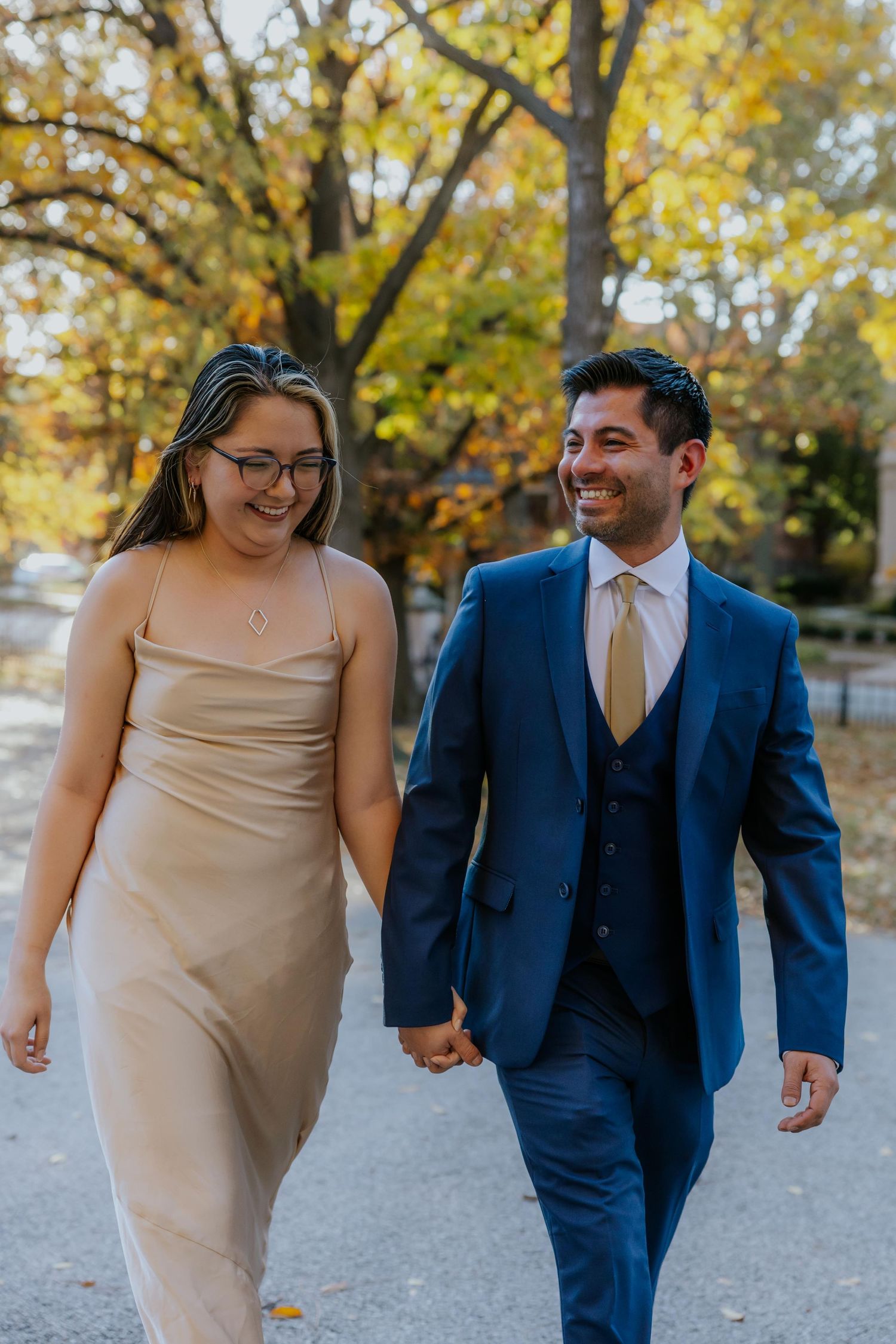 A couple shares candid moments while walking together during their engagement photoshoot at Lafayette Park in St. Louis.