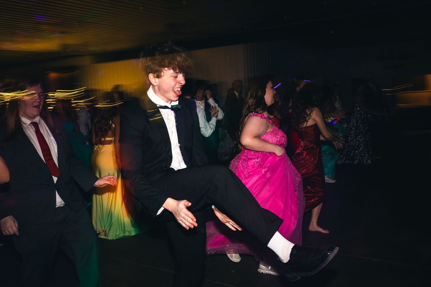 People dancing and celebrating at a dimly lit formal event.