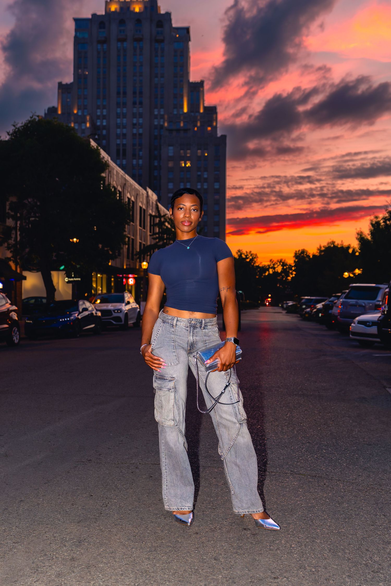 Posed portrait against a vibrant sunset sky in an urban parking lot in Central West End in St. Louis.