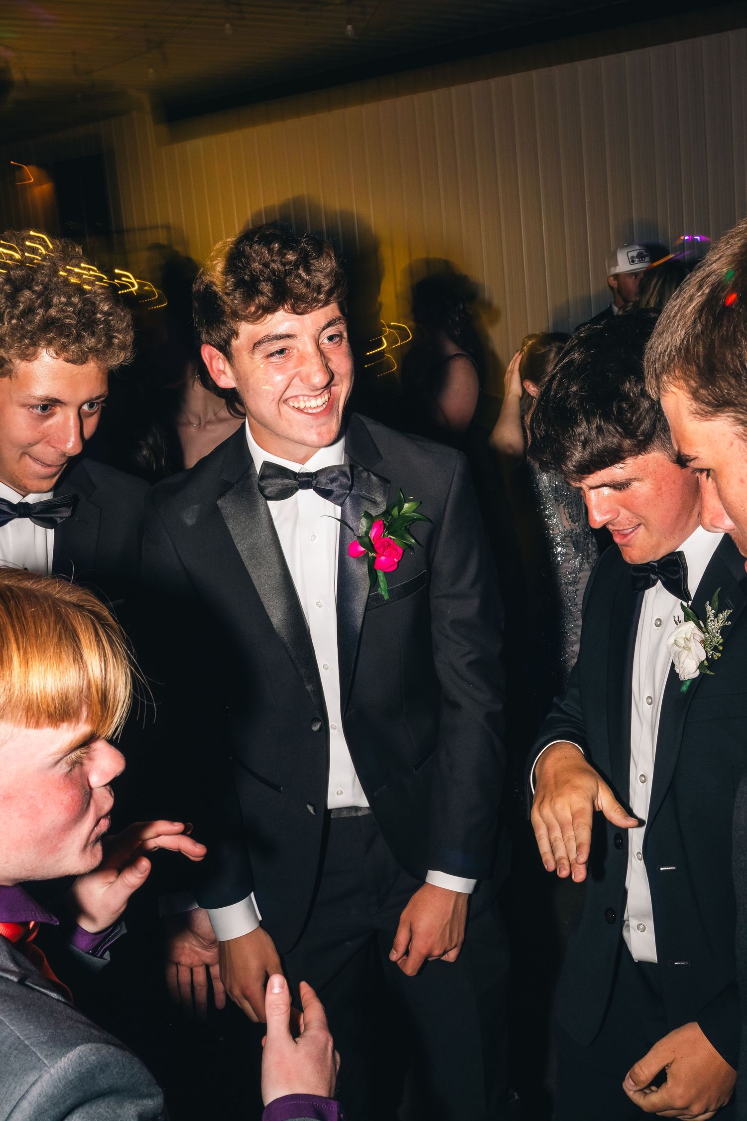 Group enjoying formal event wearing tuxedos and bow ties.
