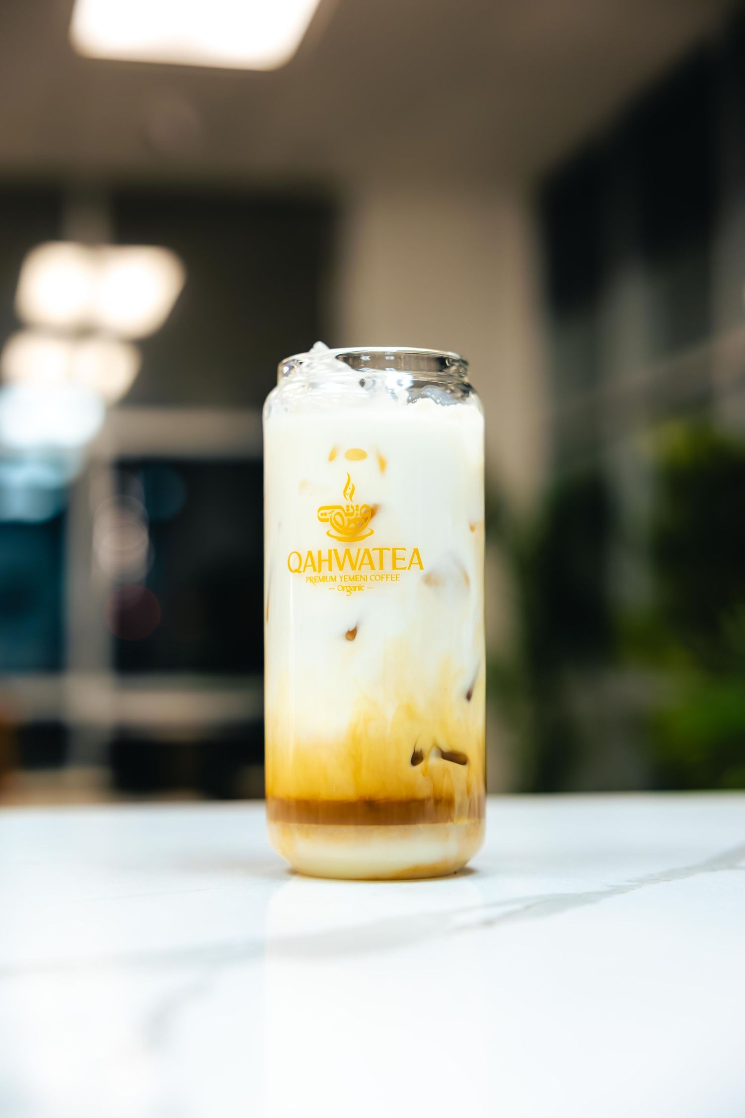 A glass of creamy beverage with Univalea branding on a white surface.