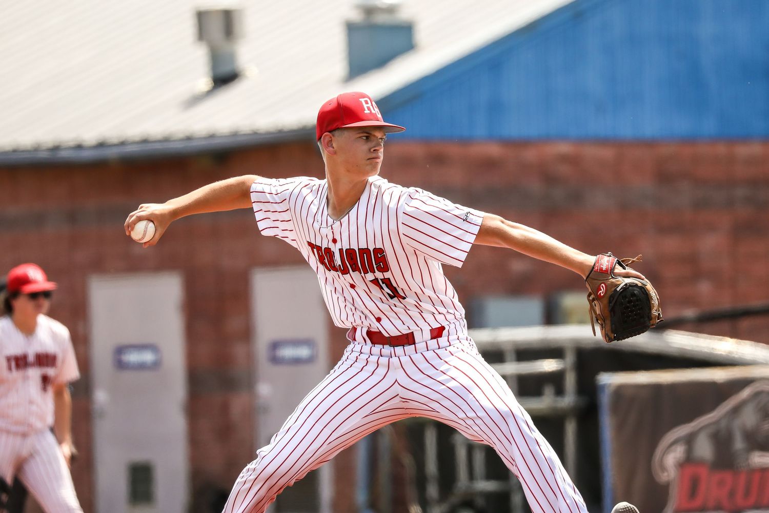 Baseball player in striped uniform pitching during game.