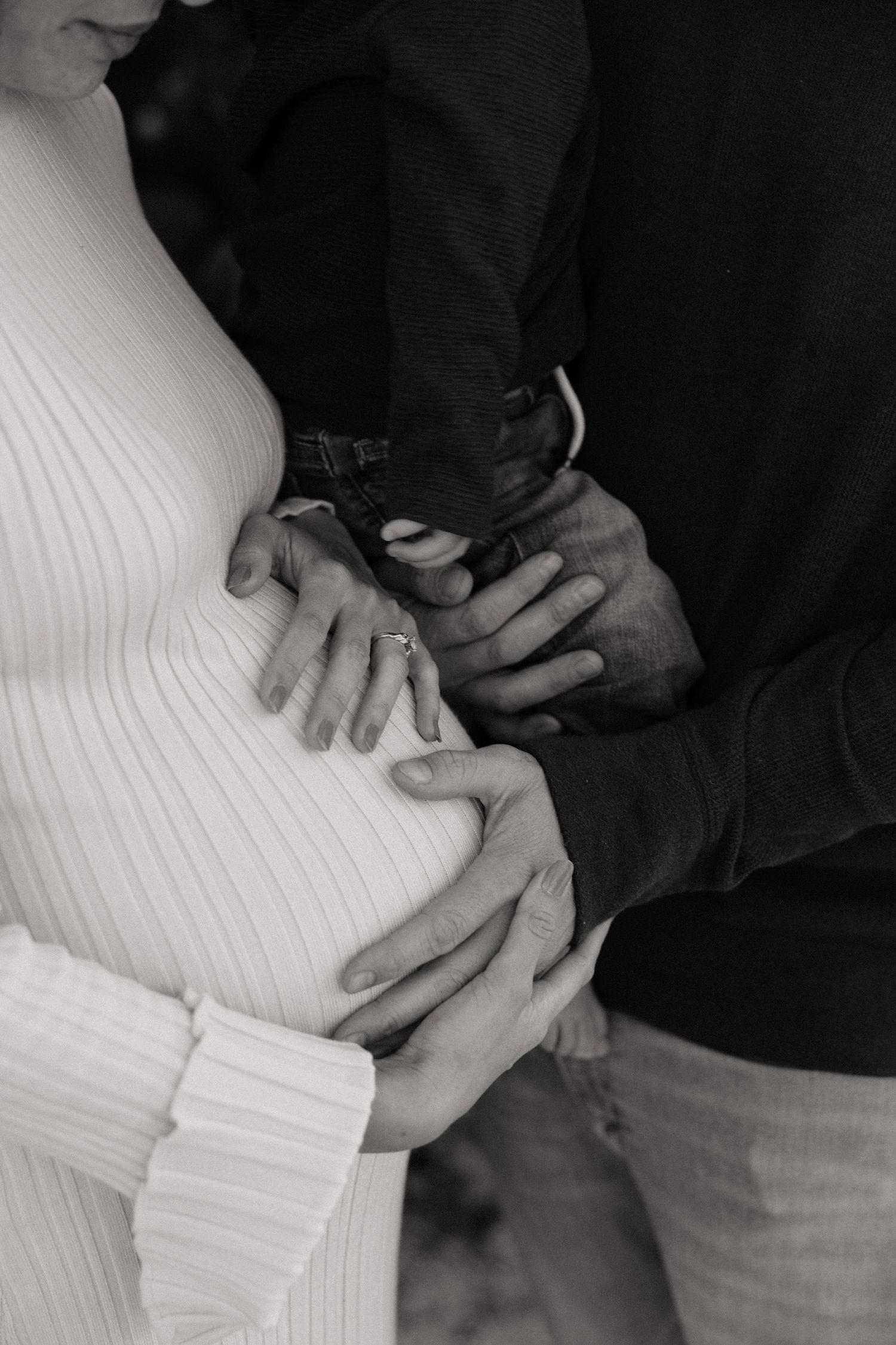 Intimate maternity photo showing hands cradling pregnant belly.