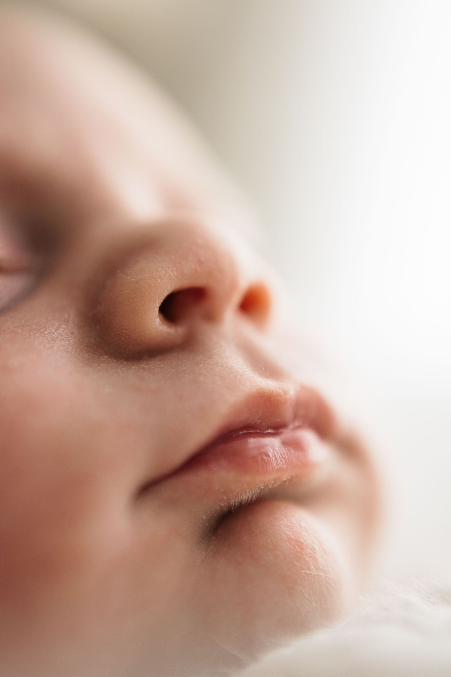 Close-up portrait of a peaceful sleeping newborn baby with soft skin and delicate facial features.