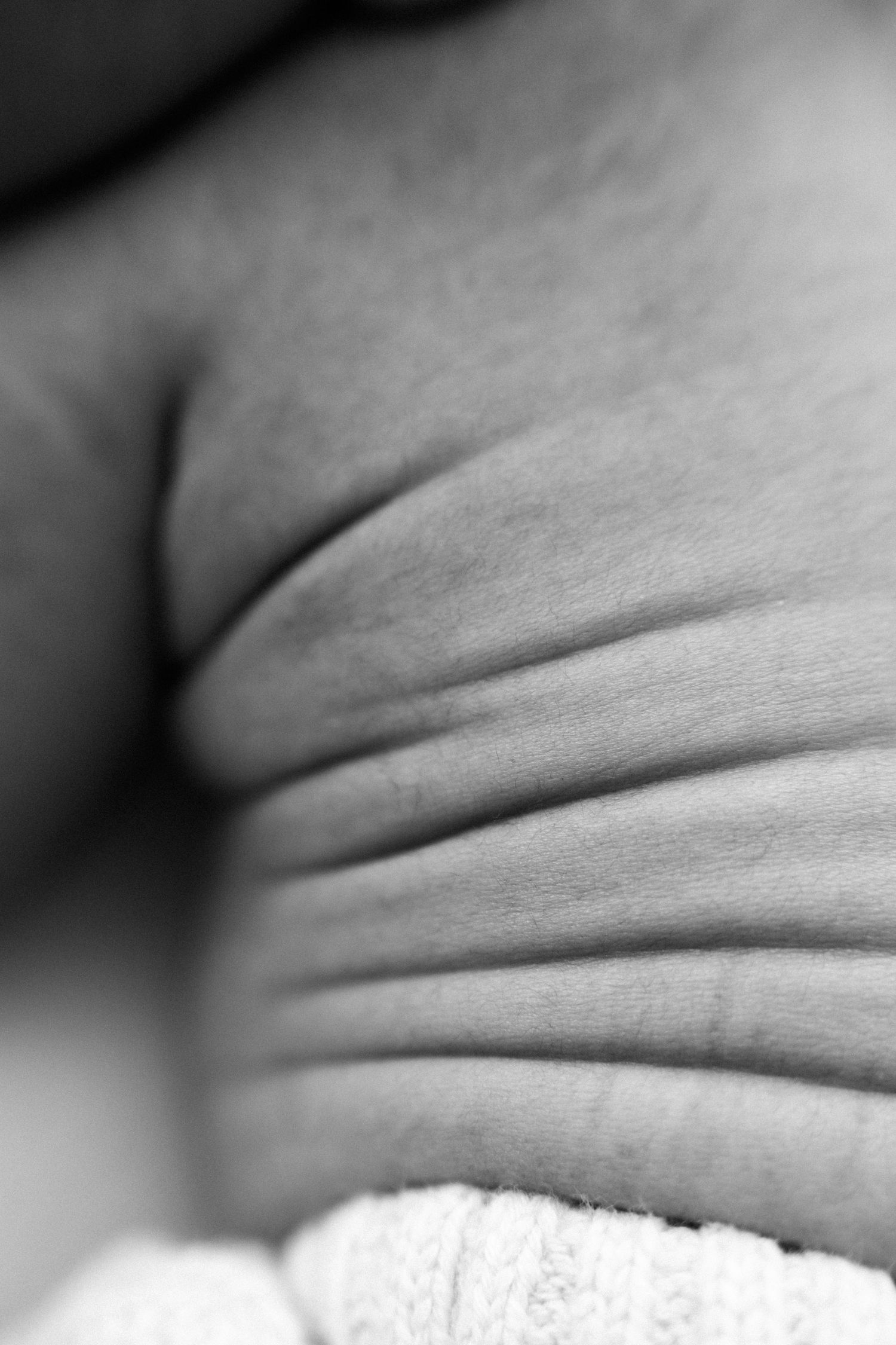 Close-up macro photograph of skin wrinkles and folds in black and white.