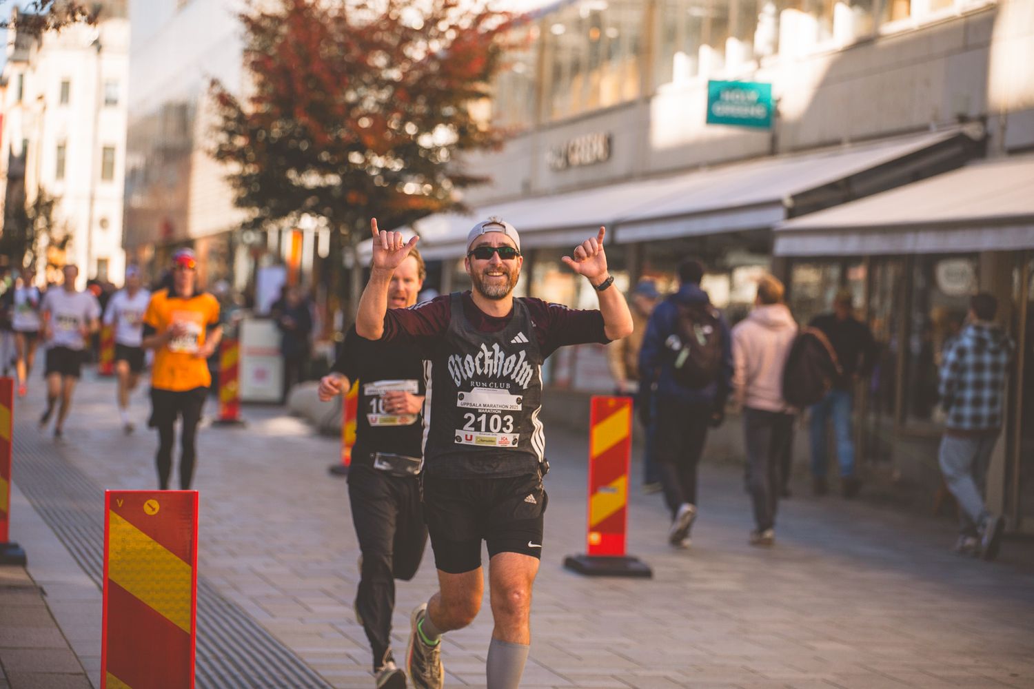 Urban marathon runners competing through city streets lined with spectators.