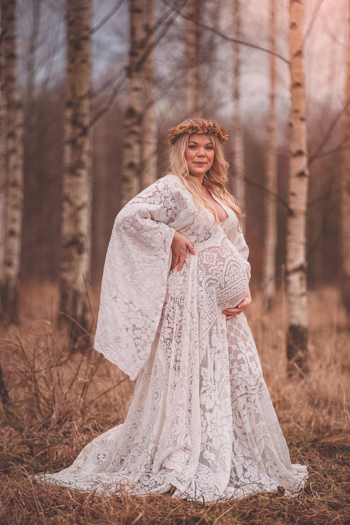 Ethereal white lace dress flows gracefully among autumn birch trees in a dreamy outdoor portrait session.