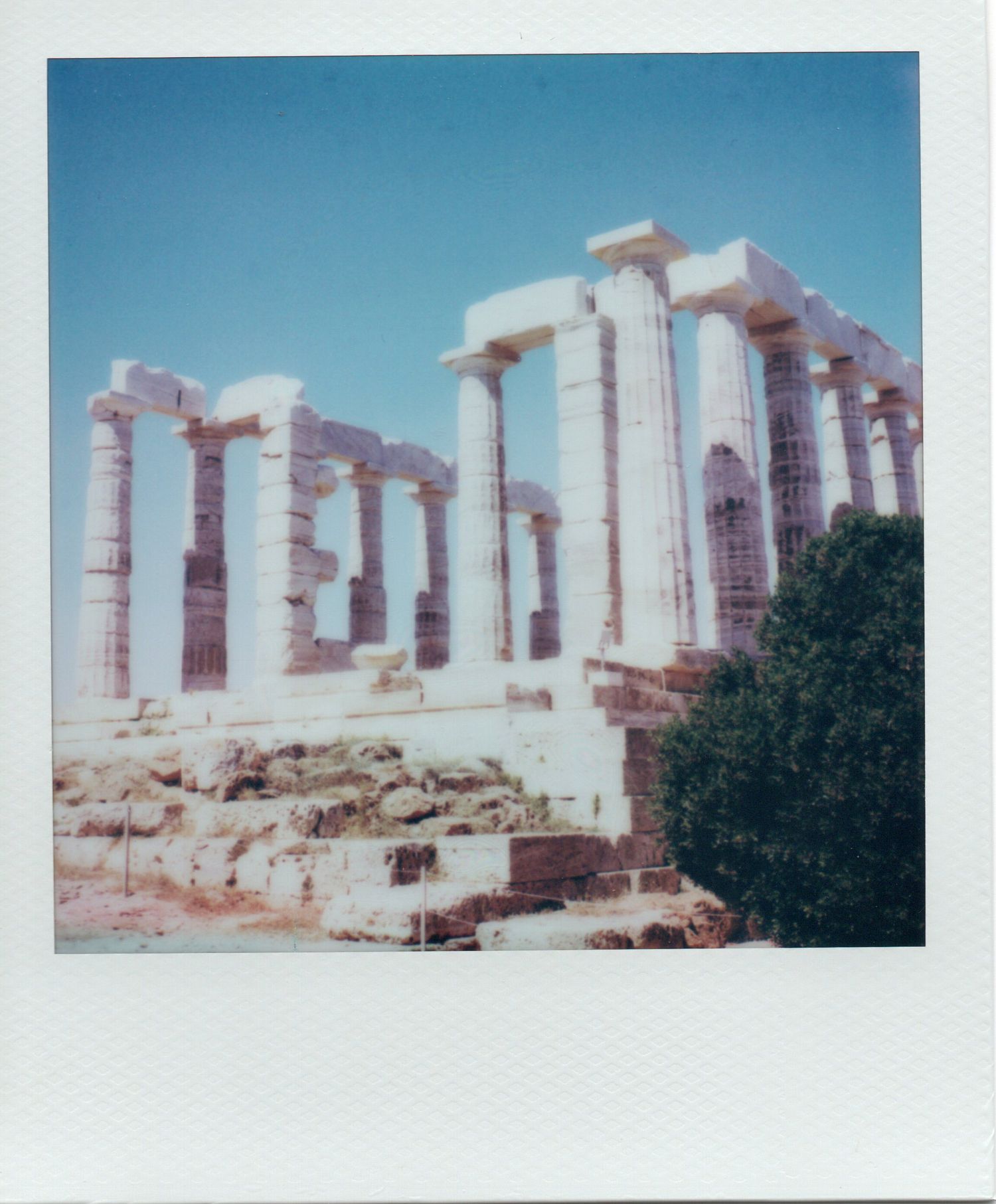 Ancient Greek Temple of Poseidon columns standing against a clear blue sky at Cape Sounion.