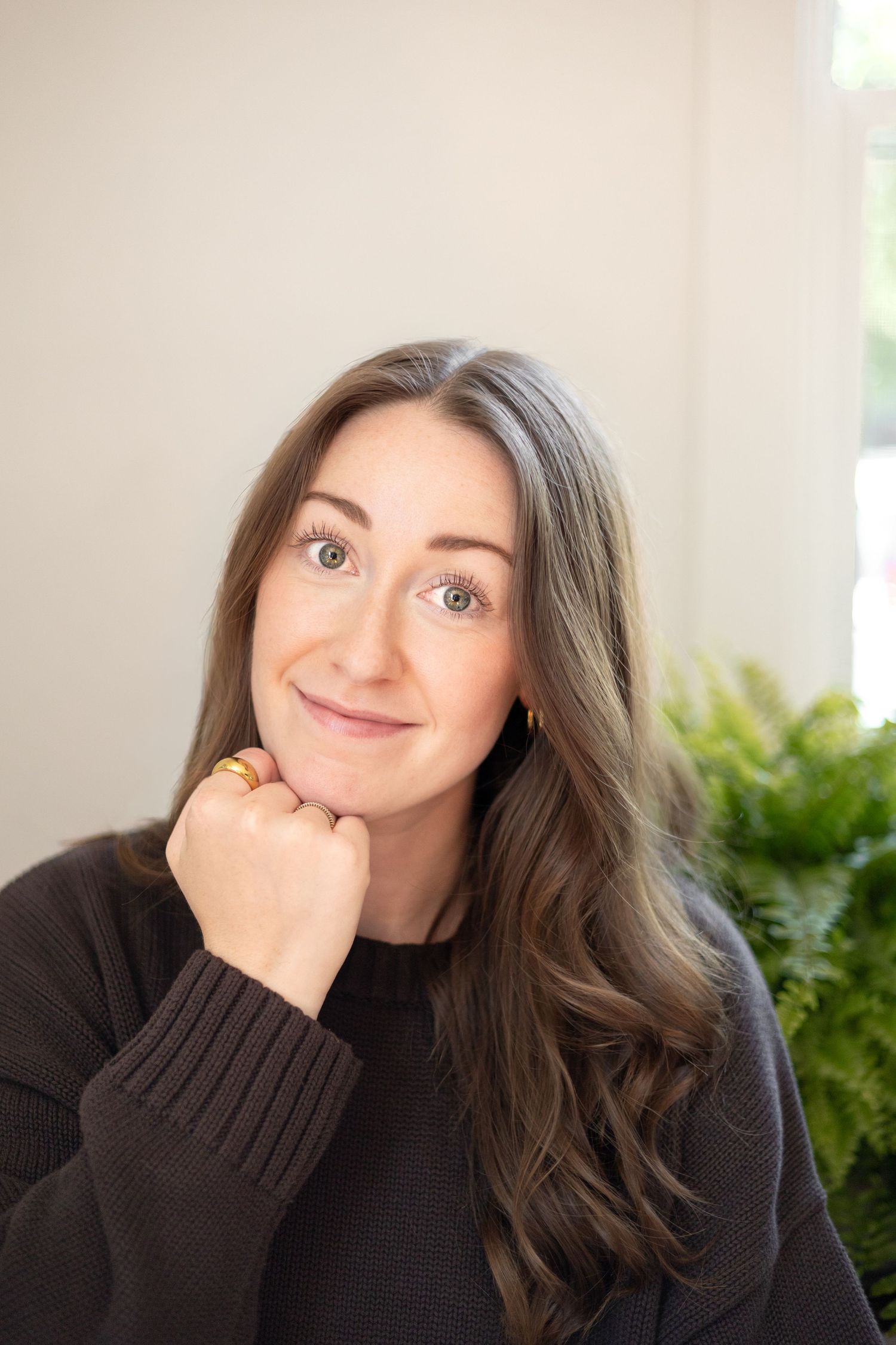 A portrait of the photographer. A young women with long brown curled hair and green eyes smiles at the camera.
