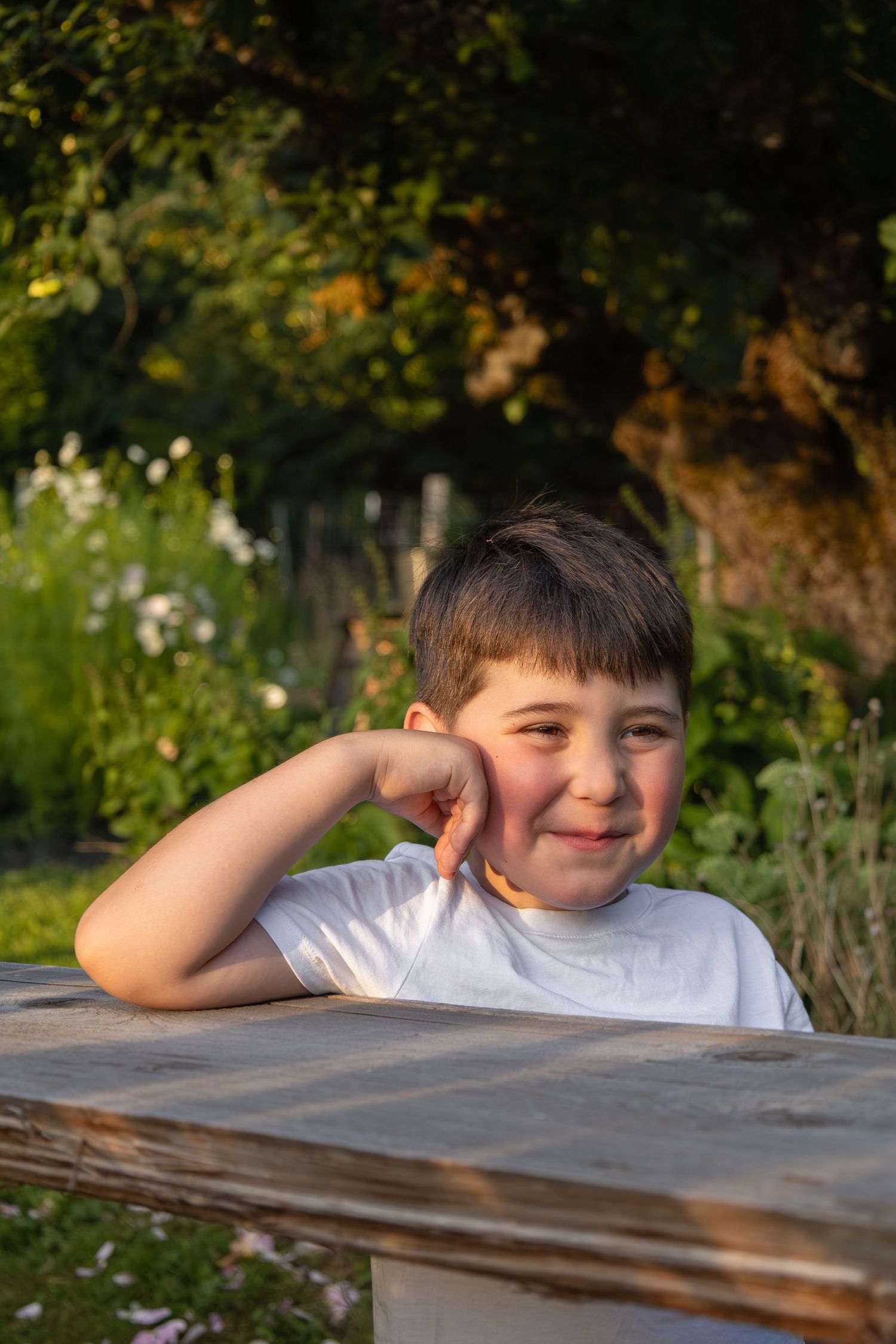 A young boy stands in a flower field while looking lovingly at his mom off camera.
