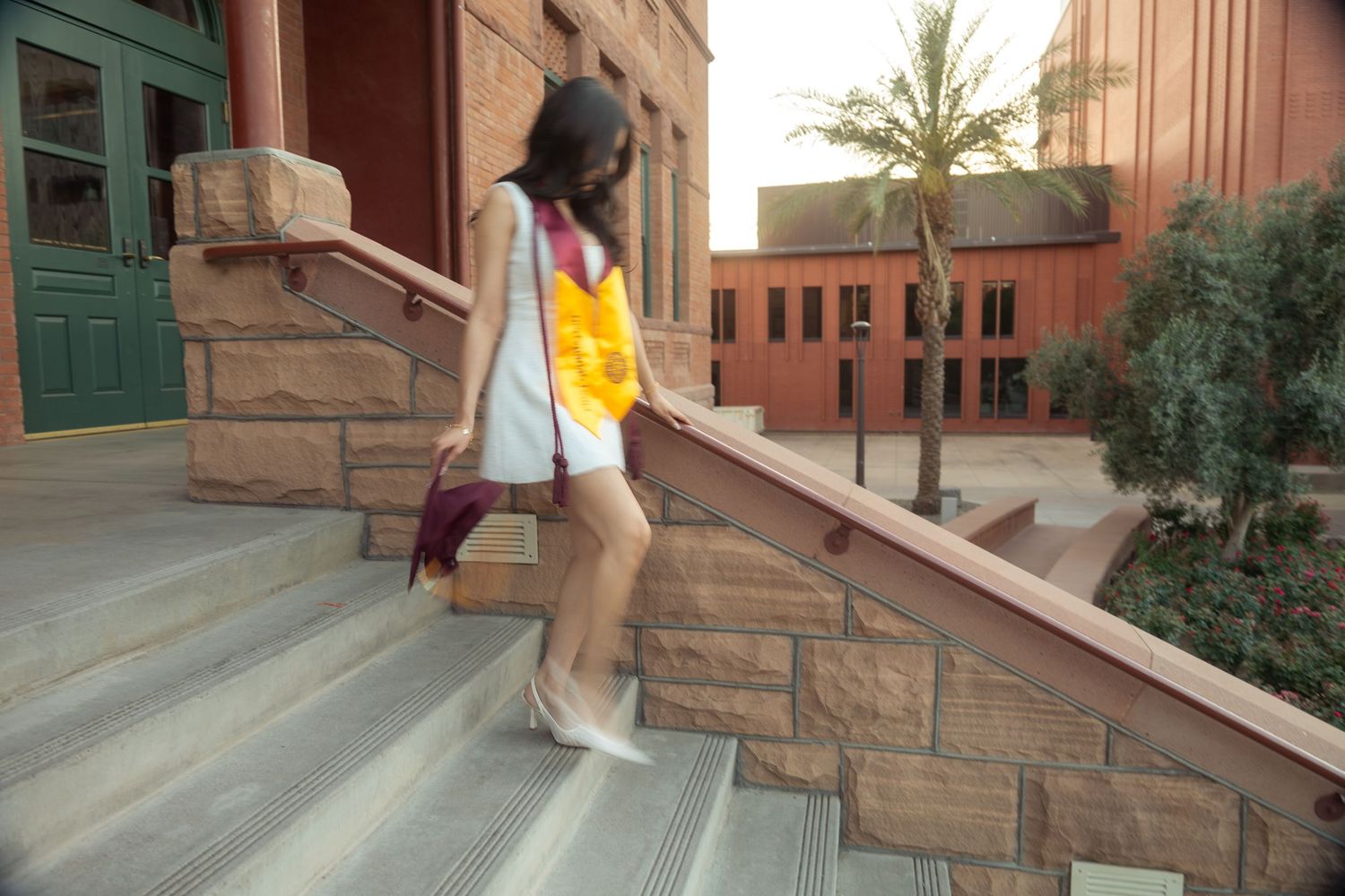 woman walking down the stairs in her regalia