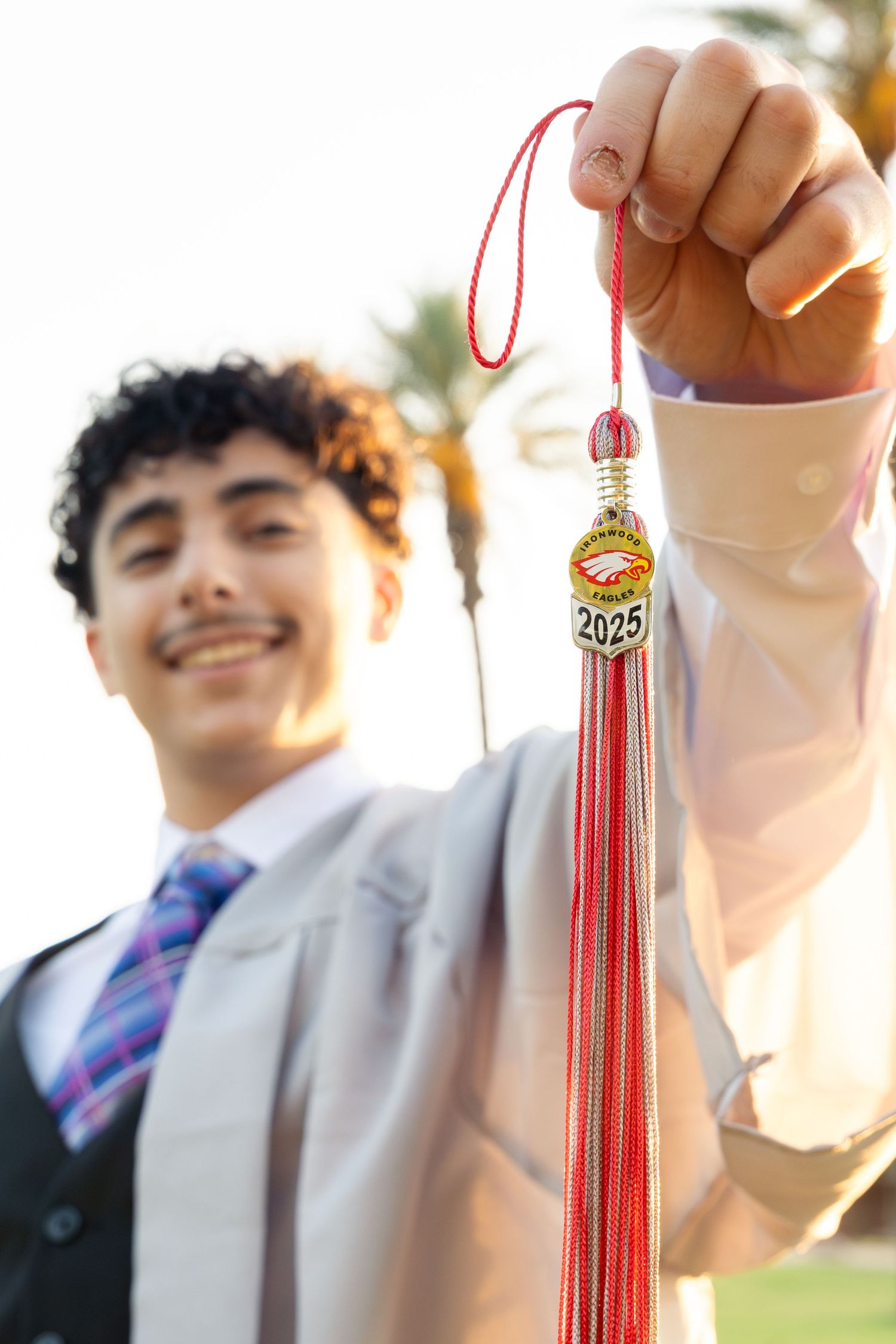 boy showing off his high school tassel to celebrate his graduation