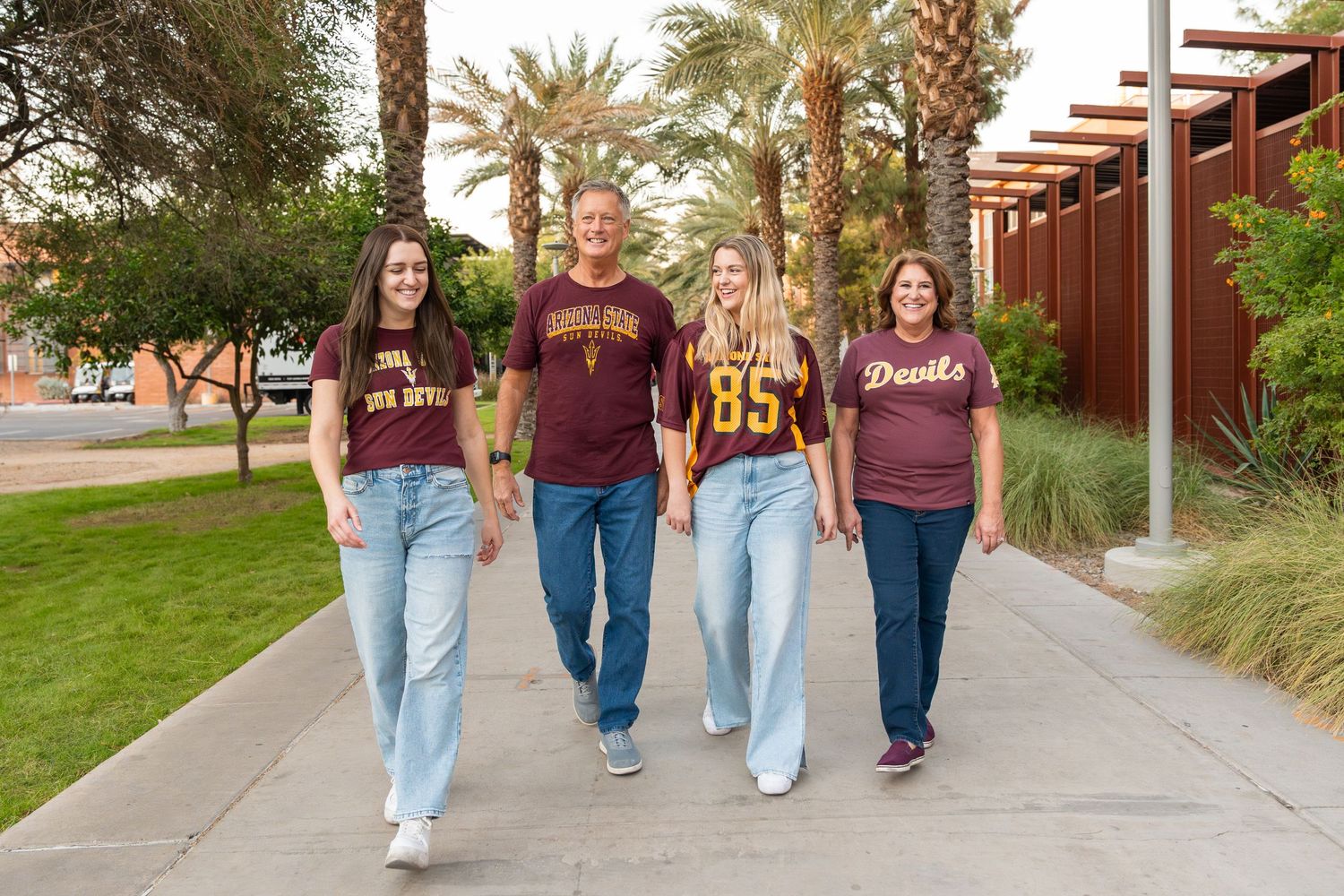 family walking down palm walk on the ASU tempe campus wearing maroon