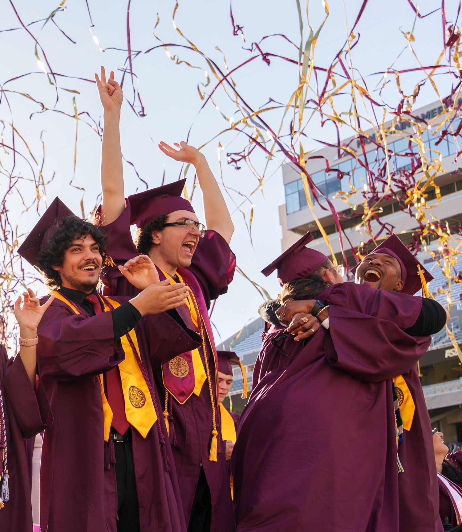 group of graduates celebrate as the confetti falls on their heads